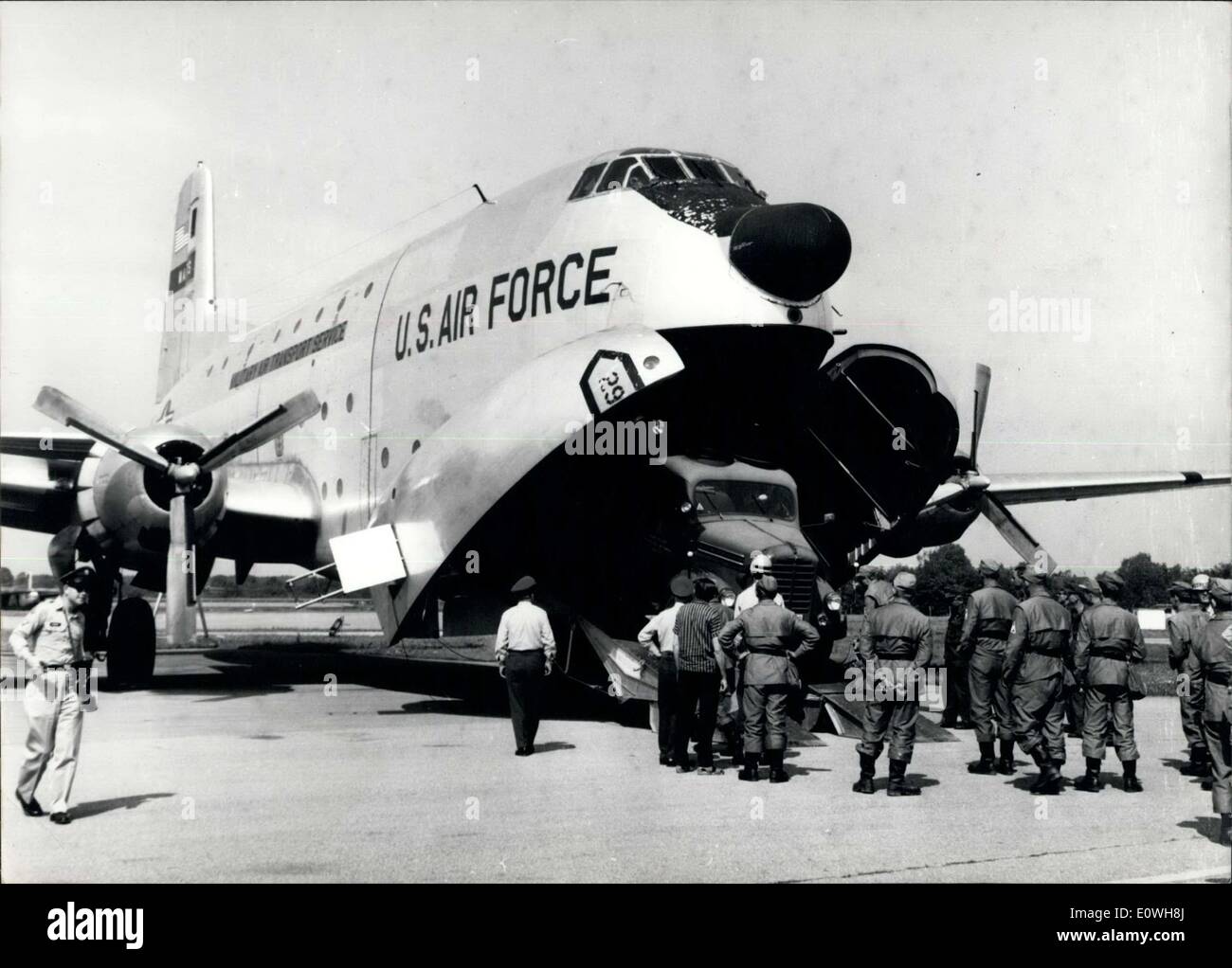 Jan. 08, 1963 - Help for Earthquake Survivors in Skopje, Yugoslavia. Three transport machines of the US Air Force started this morning (1.8.) from Military-Airport Neubiberg near Munich to Skopje. The aeroplane brought seven motor lorries, VW busses and a field citchen and also 40 persons of the technical Helpwork (Technische Hilswerk) to the ruined town to help the homeless hungry survivors. OPS: One of the motor lorries is transported into the aeroplane. On the right side the Helptroopers of the THW (Technical Helpwork) Stock Photo