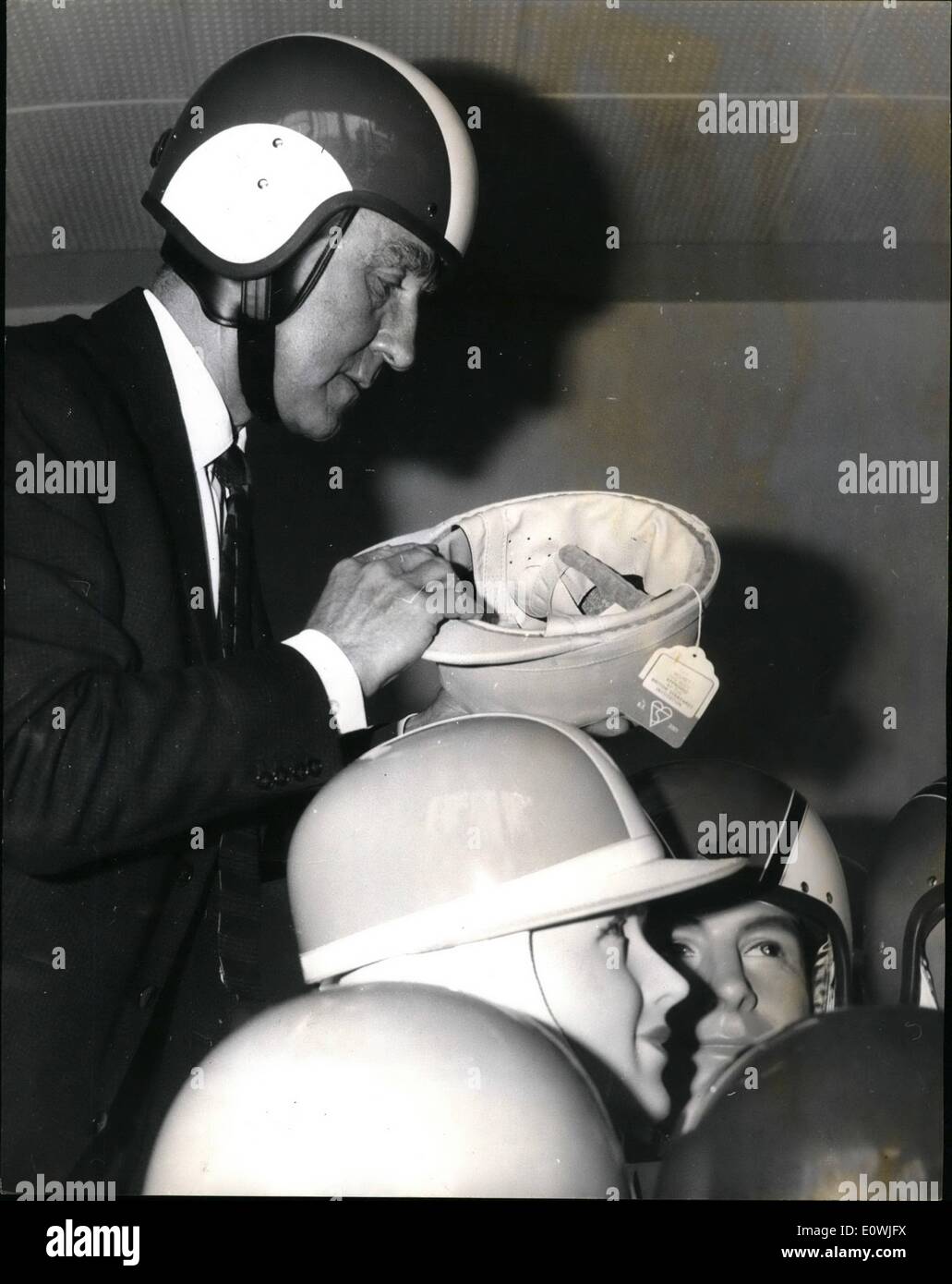 May 27, 1963 - 27-5-63 Mr. Marples launches campaign for safety helmets. Transport Minister Mr. Ernest Marples today launched a six-month campaign to encourage motor cyclist to wear safety helmets. The Minister has the power to make the wearing of safety helmets compulsory, but wants to try to persuade motor cyclists to wear them voluntarily. Photo Shows: At the press conference, Mr. Marples wearing a safety helmet, looks at some of the others that were on display. Stock Photo