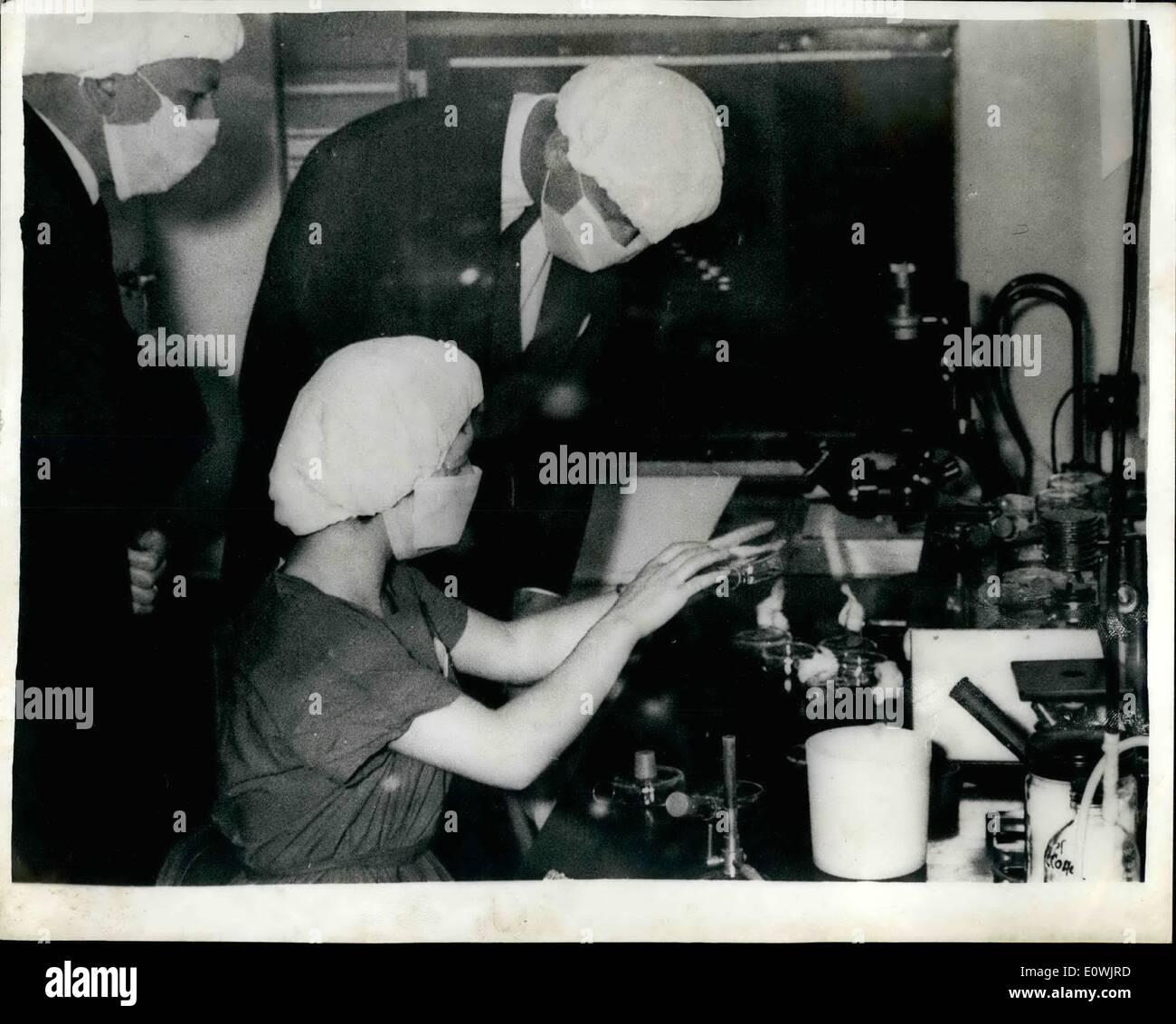 Jun. 06, 1963 - Can you recognise him?: Prince Philip wearing a mask and hat examines an item being shown to him by Miss Beryl Maders, a junior technician, while he was inspecting the Tissue culture laboratory during his visit to the National Spastics Society's Child Health Research Unit at Cameron House Guy's Hospital today. The duke is president of the society. Stock Photo