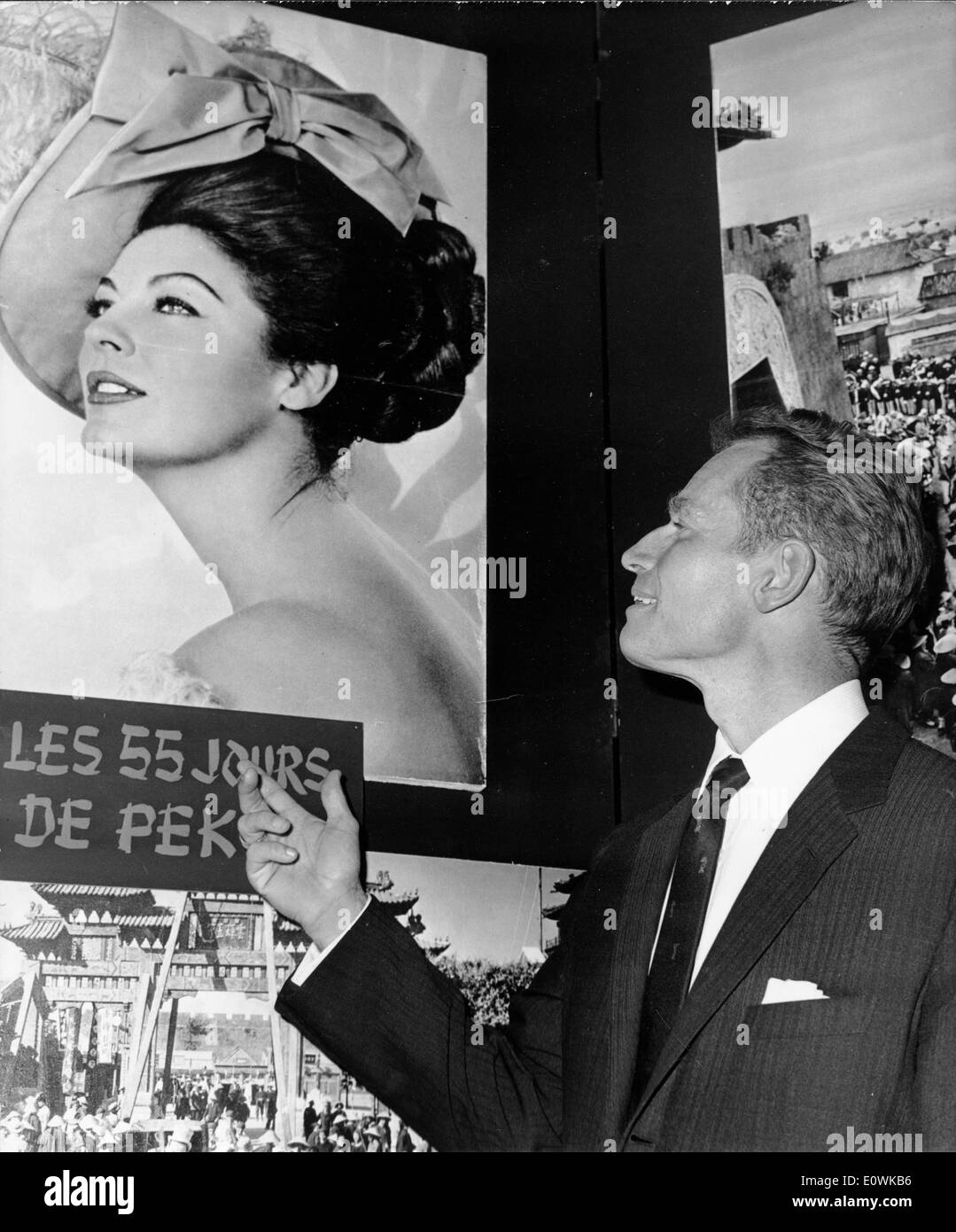 Actor Charlton Heston looking at a poster for '55 Days at Peking' Stock Photo