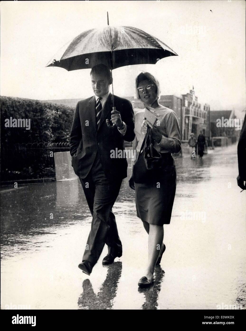 Jul. 06, 1963 - Heavy Rain Delays Play At Wimbledon: Heavy rain was delaying the start of play in the tennis tournament at Wimbledon this afternoon. Photo shows One of today's finalist Billie Jean Moffitt shares an umbrella with a friend at Wimbledon this afternoon. Stock Photo