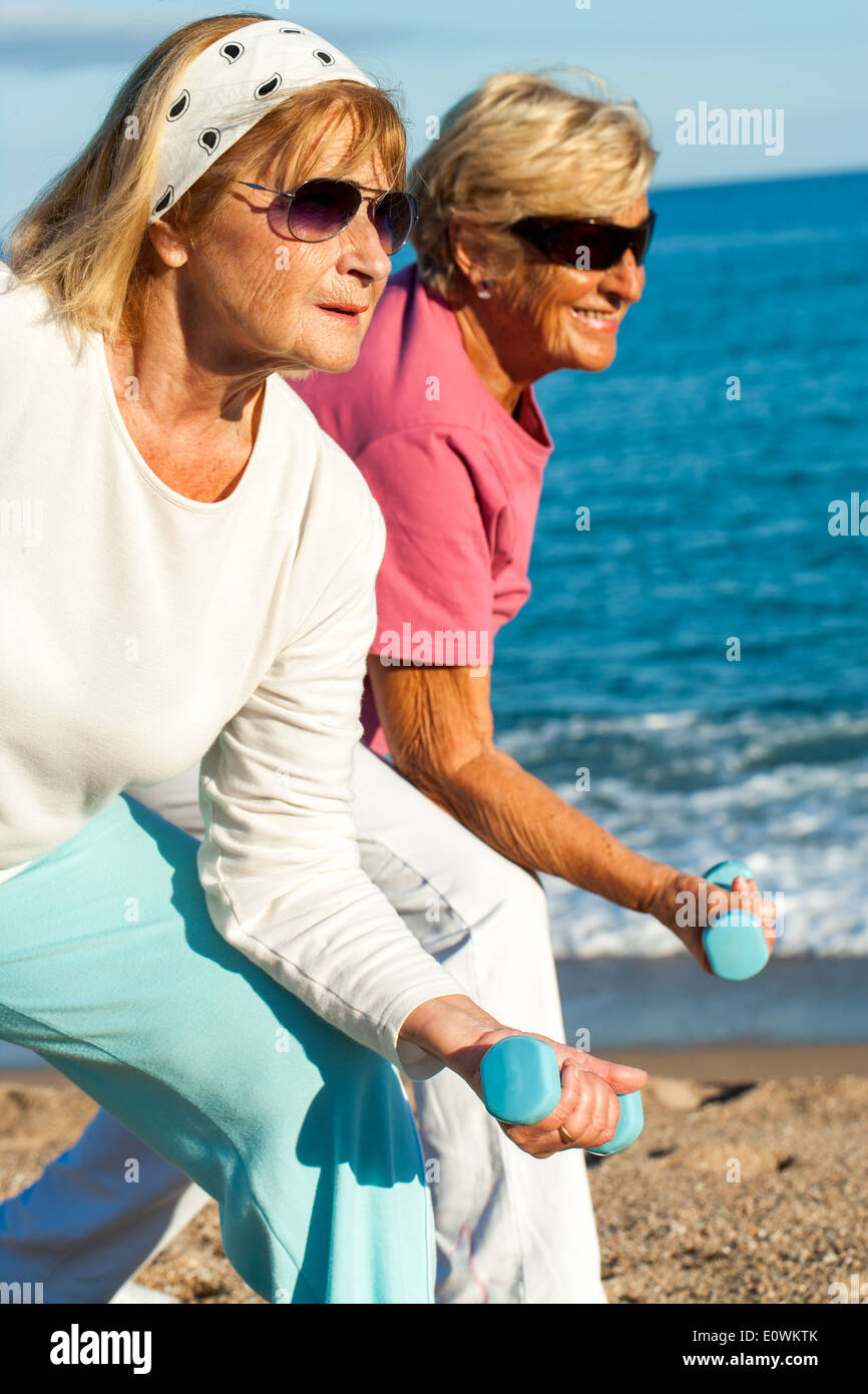 Elderly ladies doing workout on beach. Stock Photo