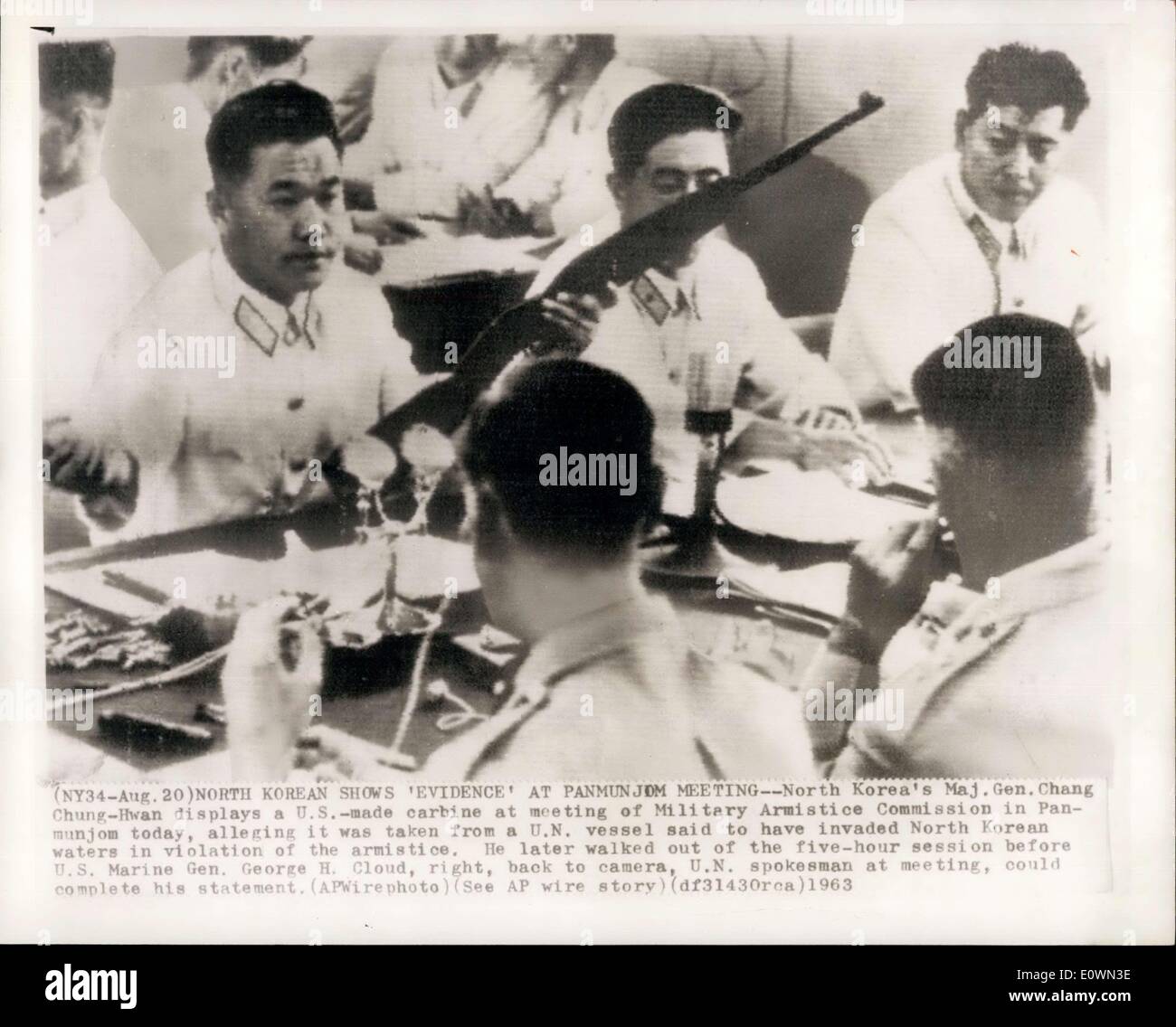 Aug. 20, 1963 - North Korean Shows 'Evidence' At Panmunjom Meeting - North Korea's Maj. Gen. Chang Cahung -Hwan display a U.S. - made carbine at meeting of military Armistice commission in Panmunjom today. alleging it was taken from a U.N. vessel said to have invaded North Korean waters in violation of the armistice. He later walked out of the five-hour session before U.S&gt; Marine Gen. George H. Cloud, right, back to camera, U.N. spokesman at meeting, could complete his statement Stock Photo