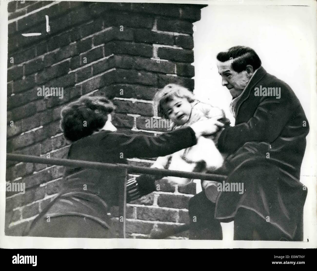 Mar. 03, 1964 - Rooftop Drama in Bloomsbury: for 85 minutes yesterday, as hundreds of people watched from below, 30-year-old Thomas French stood precariously balanced at the top of a four story building 60 feet above the street in Bloomsbury London, holding his 18-month-old son Stewart in his arms, threatening to jump off. French said that he had been evicted from his home, and that his wife had left him. Fireman and helpers spread tarpaulins below, and three policemen and women police constable Margaret cleland, 23. gathered on the roof and tried to reason with the man Stock Photo