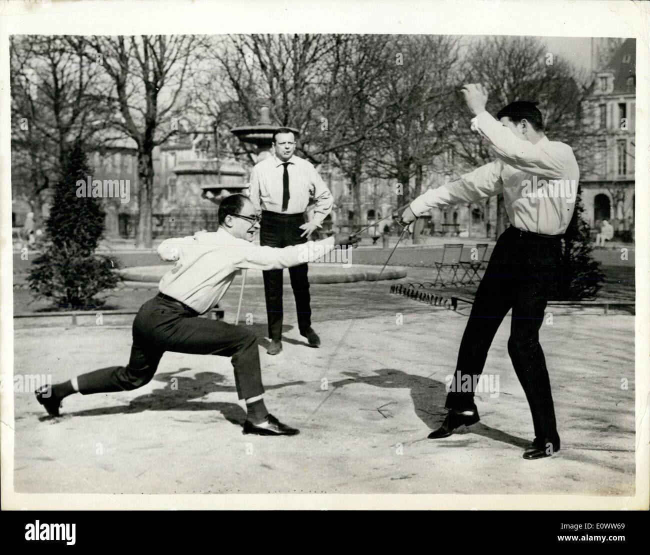 Mar. 11, 1964 - Journalists Duel - Over a Book: In Paris this morning, two Journalists, Monsieur Eskanazy and Monsieur Mordacq fought a duel in the place des Vosges. The had disagreed over a book written about Leon Daudet, a French fascist of the 1930's. The duel came to an end when Monsieur Moedacq was wounded on the right side by his opponents infantry sword. Picture Shows: The Scene during the duel, M. Eskanazy is on the left, M. Mordacq is right, watched by the Master at Arms. Stock Photo