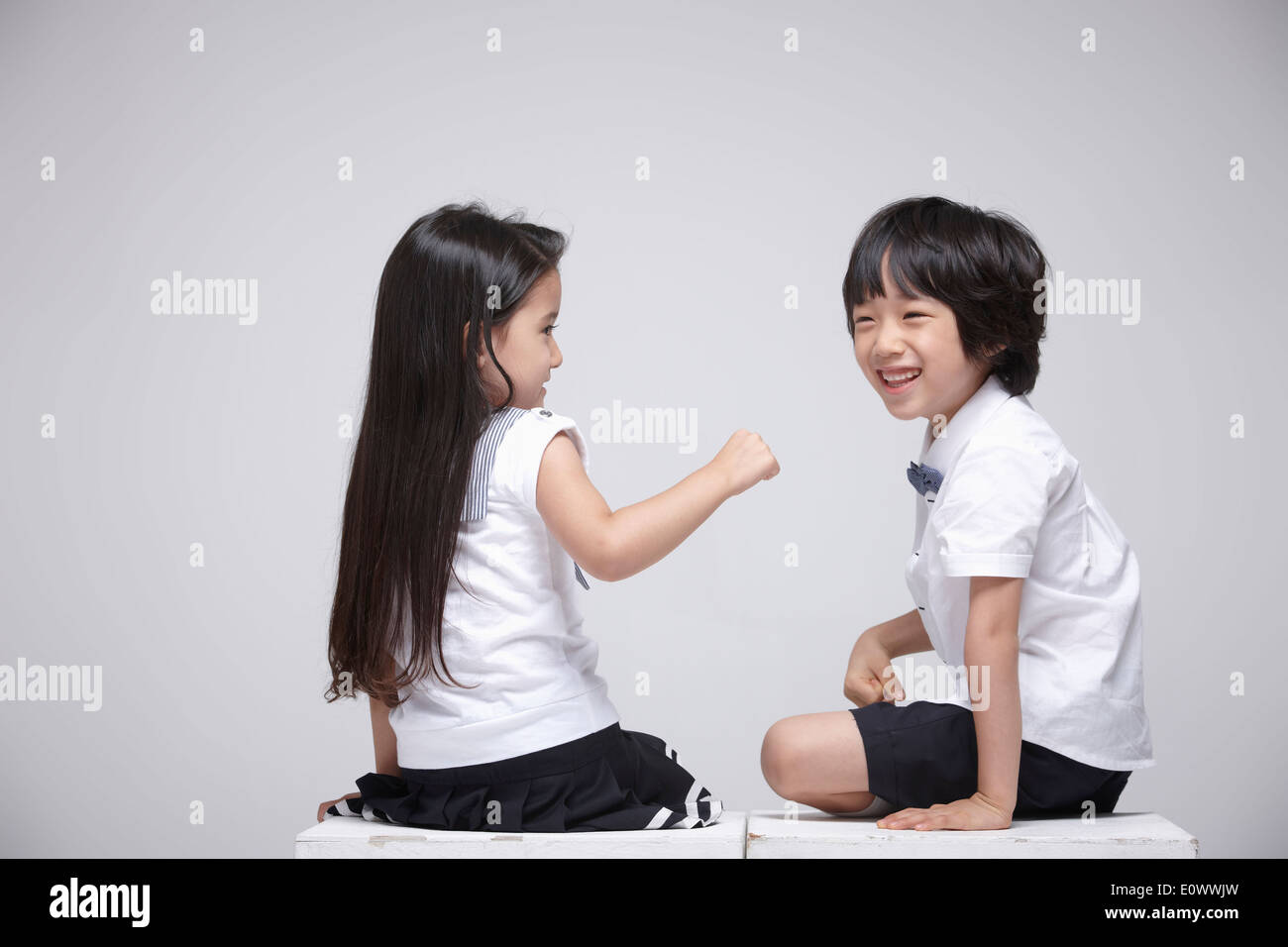 a boy and a girl sitting next to each other Stock Photo - Alamy