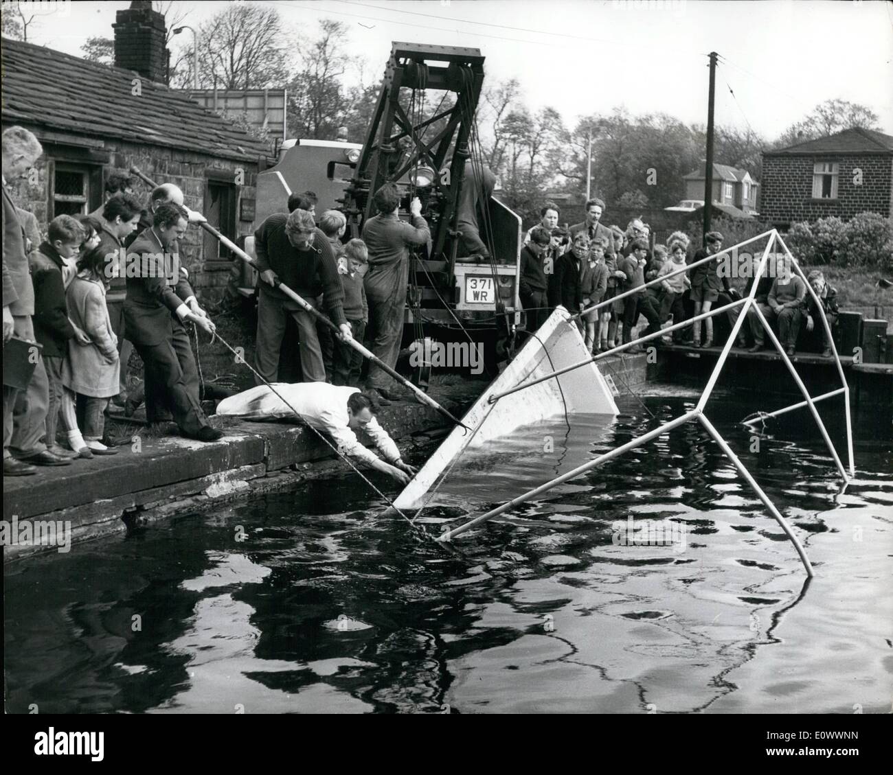 May 05, 1964 - Rescuing The Scuttled Pie Dish: Yesterday an unusual rescue operation was carried our at Miffield, Yorks, when the Denby Dale Pie Dish - the world's largest - was raised from the bottom of the canal where it had been sunk by a gang of youngsters. The dish had been propelled along the canal from it's makers to Denby Dale, where it is to be filled with a mammoth pie to commemorate the births of the four Royal babies Stock Photo