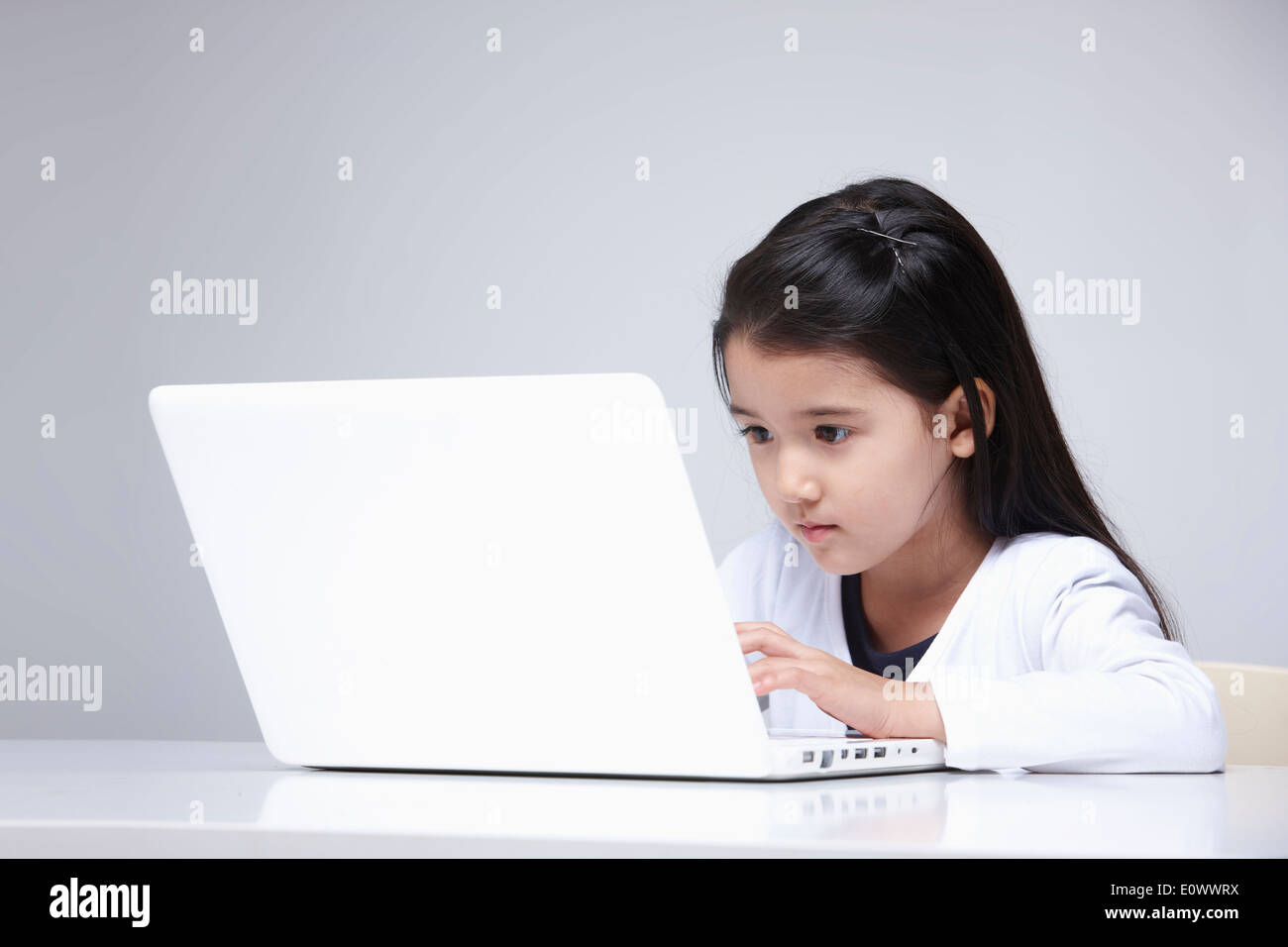 a girl playing with the laptop Stock Photo - Alamy
