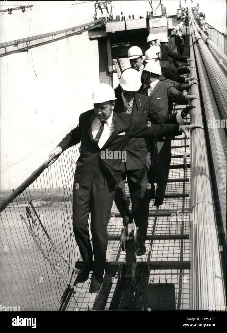Jun. 06, 1964 - Mr. Marples on a Tightrope: Yesterday, Transport Minister Mr. Ernest Marples paid a visit to the new Severn Bridge under construction near Gloucester, which will form part of the London SOuth Wales Motorway and will form a vital link between England and Wales. Mr Marples went to the top of the bridge to watch the spinning of the main suspension cables. Photo shows Mr. Maples walks along a walkway at the topof the new Severn Bridge. Stock Photo