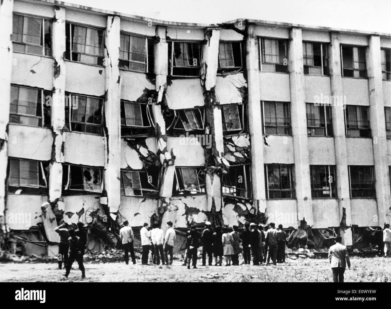 FILE PHOTO - Jun 17, 1964 - Hakodate, Japan - People look at a collapsed four-story building on the Hakodate University campus in Hokkaido after the magnitude-7.5 Niigata earthquake struck. After the quake struck northern Japan, tsunamis drove ships on the rocks and sunk many fishing boats. Stock Photo