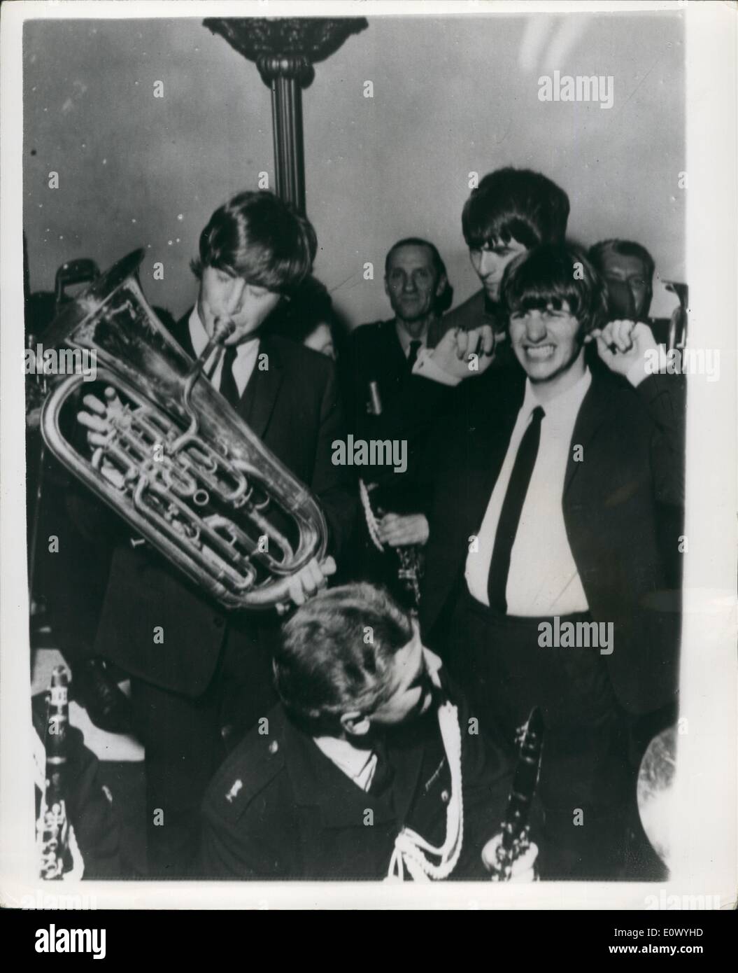 Jul. 07, 1964 - 100,000 Fans Welcome Back The Beatles To Liverpool For Their Film Premiere: In Liverpool last night over a 100,000, fans welcomed back the Beatles for their Premiere of their latest film A Hard Days Night, during the welcome over 40, people for shock in the swaying and streaming crowds. Photo shows During the reception John Lennon trying to play a tune on the Tuba, but as you can sea Ringo with his fingers in his ears cant stand the sound at the back is George Harrison. Stock Photo