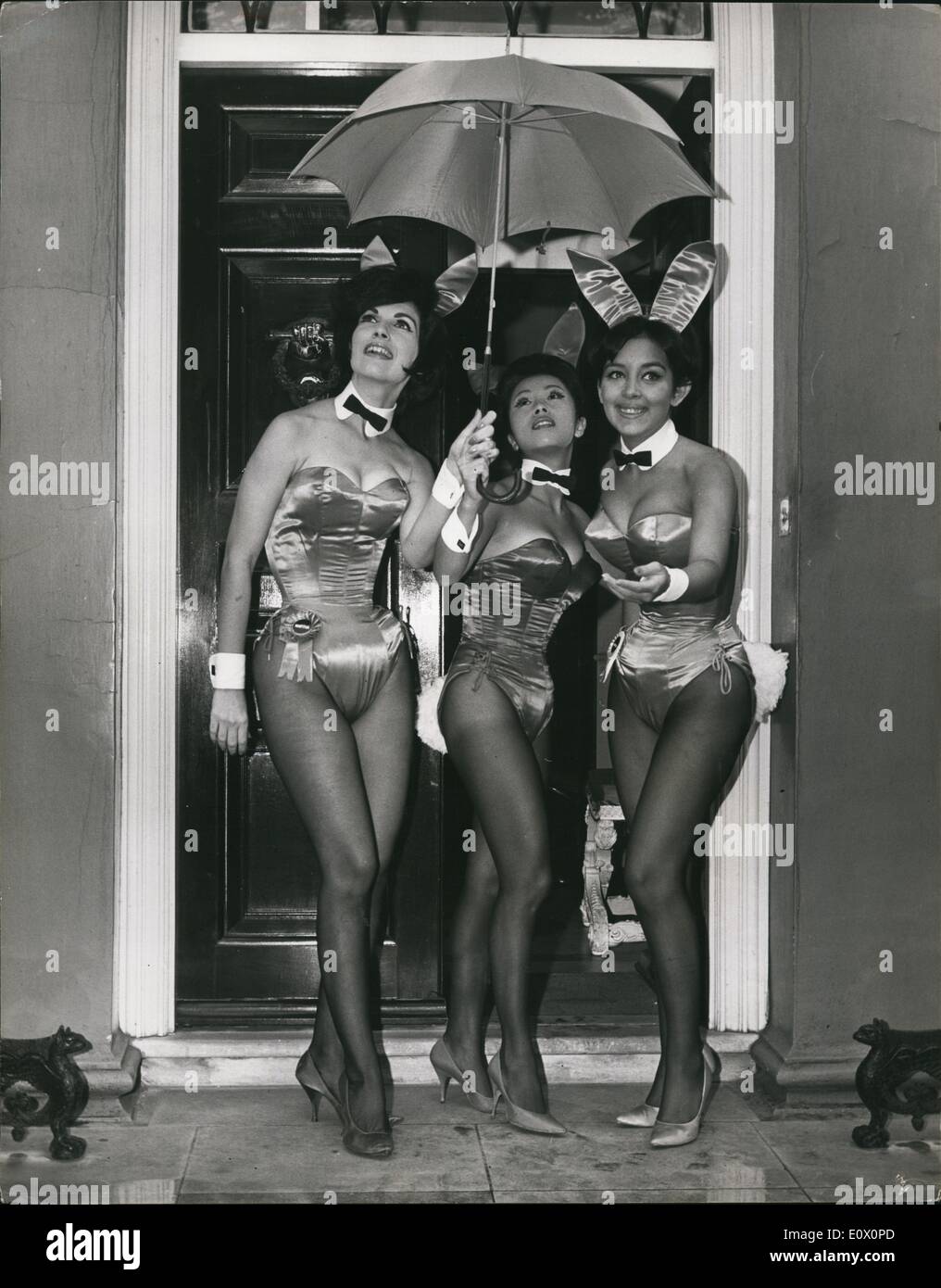 Oct. 10, 1964 - Playboy Club Bunnies in London: Seven beautiful bunnies from America's famous Playboy Clubs, have arrived in London for a week's visit. The girls all 'Bunny Award' winners chosen from over 700 bunnies who staff the ten Playboy clubs, were selected for their appearance, graciousness and popularity. While in London they will appear on a number of television programmes. Photo shows Three of the bunnies share an umbrella in rainy London today. They are (L to R): Martha Louise Hellwig, of New Orleans, Elizabeth Yee, of New York; and Katherine Fitzpatrick of Detroit. Stock Photo
