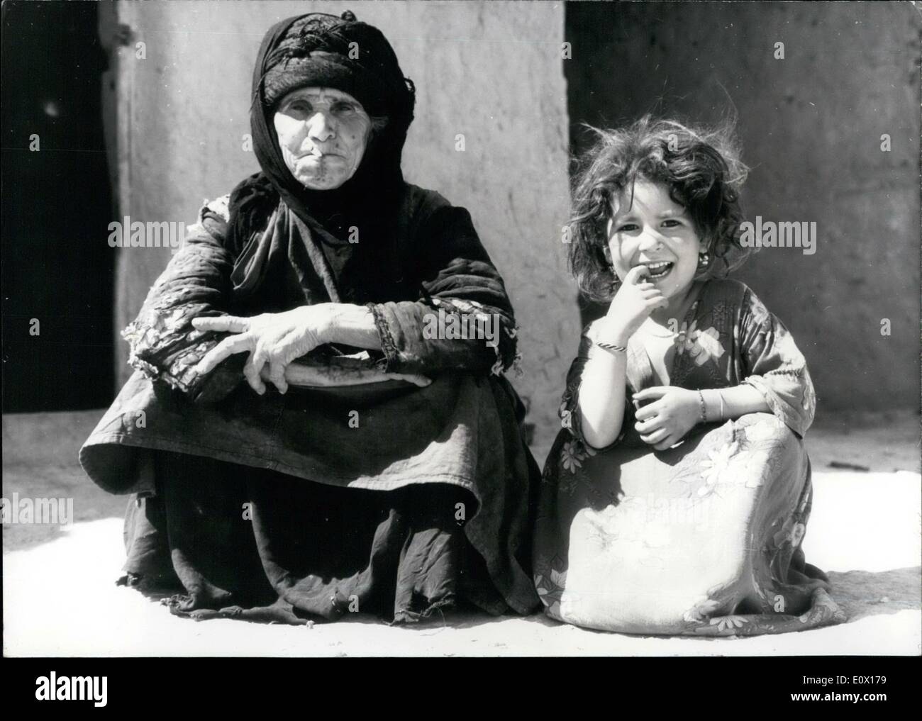 Dec. 12, 1964 - It is Pleasant living here. .......that seem to think grandmother and the little girl, who are looking very satisfied and happy, sitting in front of their home in a little village in the North of the Iraq. During the old wife of the Bajaden-clan is smoking a cigarette with pleasure, the beautiful girl is smiling to the photographer, who wants to take a shot of her. Stock Photo
