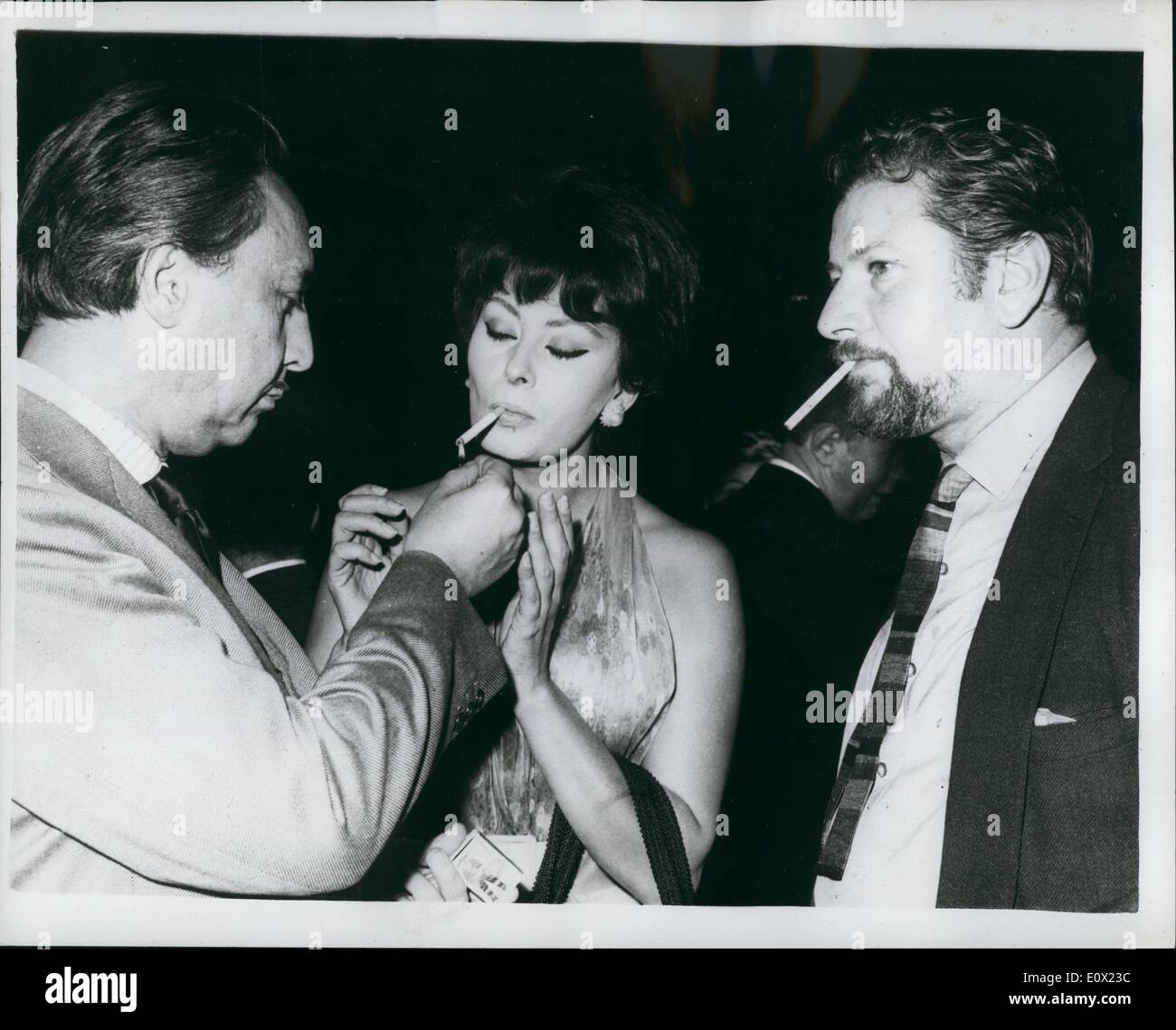 Nov. 11, 1964 - Sophia Loren Receives Guests at Film Party: Popular Italian Film Sophia Loren held a Cocktail party at tje Boulogne studios- Paris last night- where she is working on her newest film '' Lady L''. Photo Shows Sophia Loren receives a light for her Cigarette from Romain Gary (left) author of the film story-watched by Peter Ustinov at the party last night. Stock Photo
