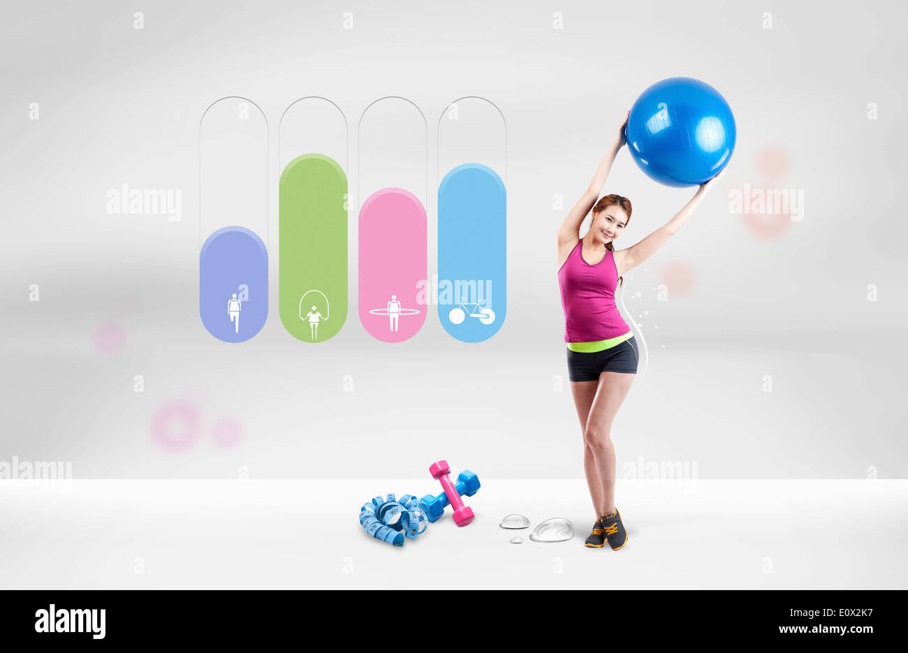 a fit woman holding a Pilates ball in the air Stock Photo - Alamy