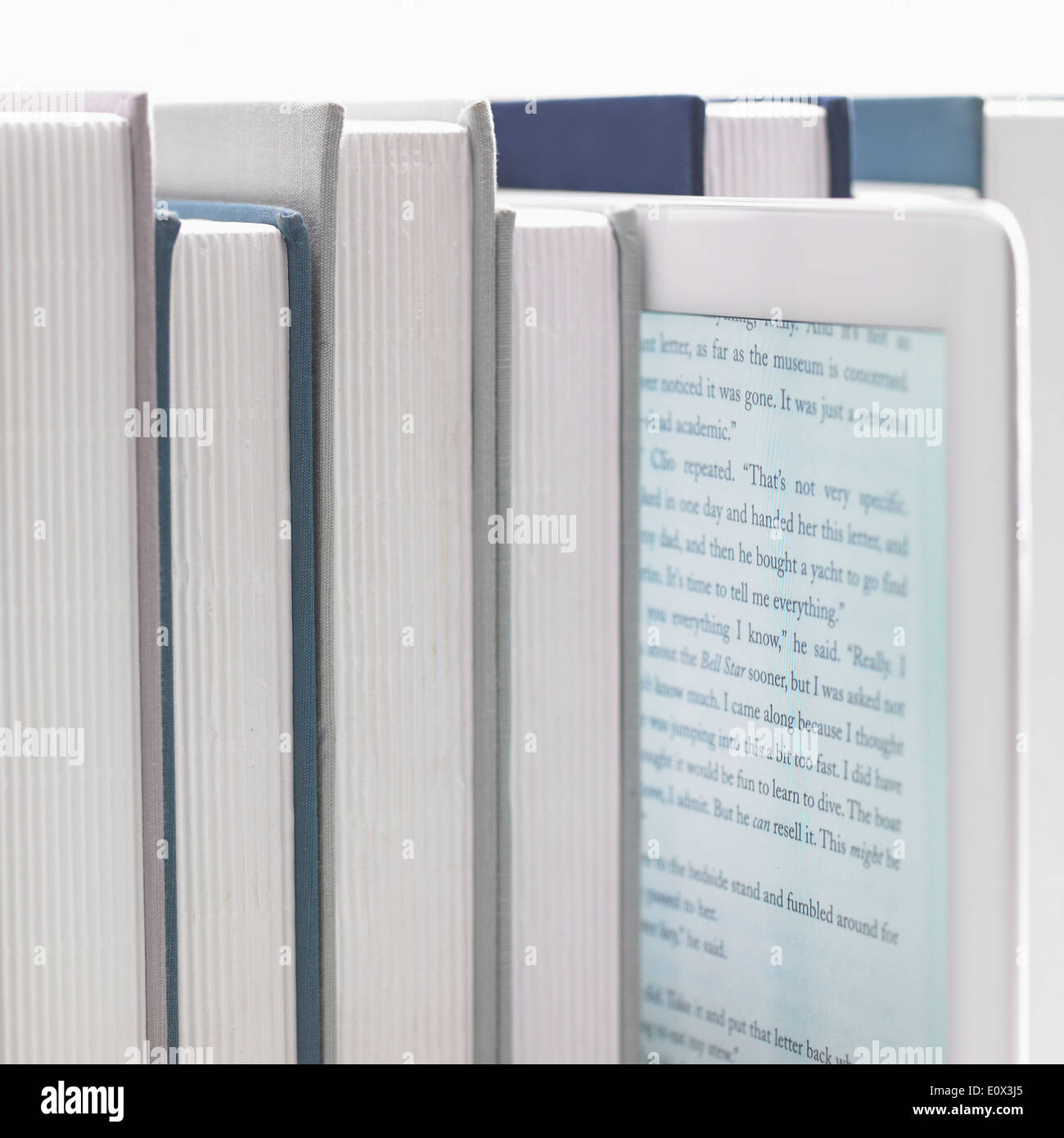 an uneven row of books with a tablet in the middle Stock Photo