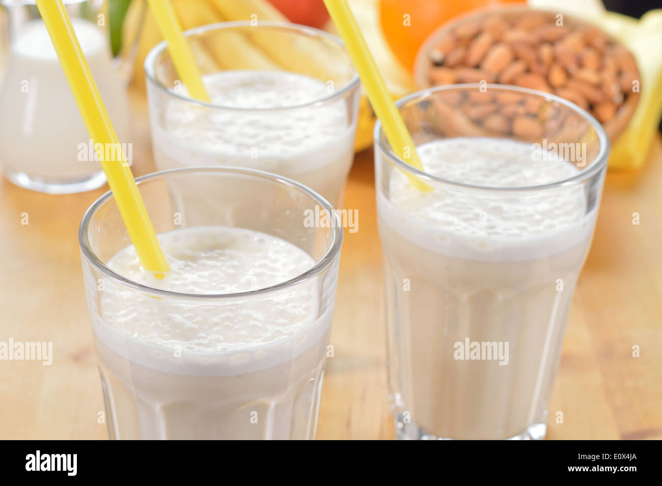 Banana and almond milk smoothie in a glass on a kitchen table. Summer