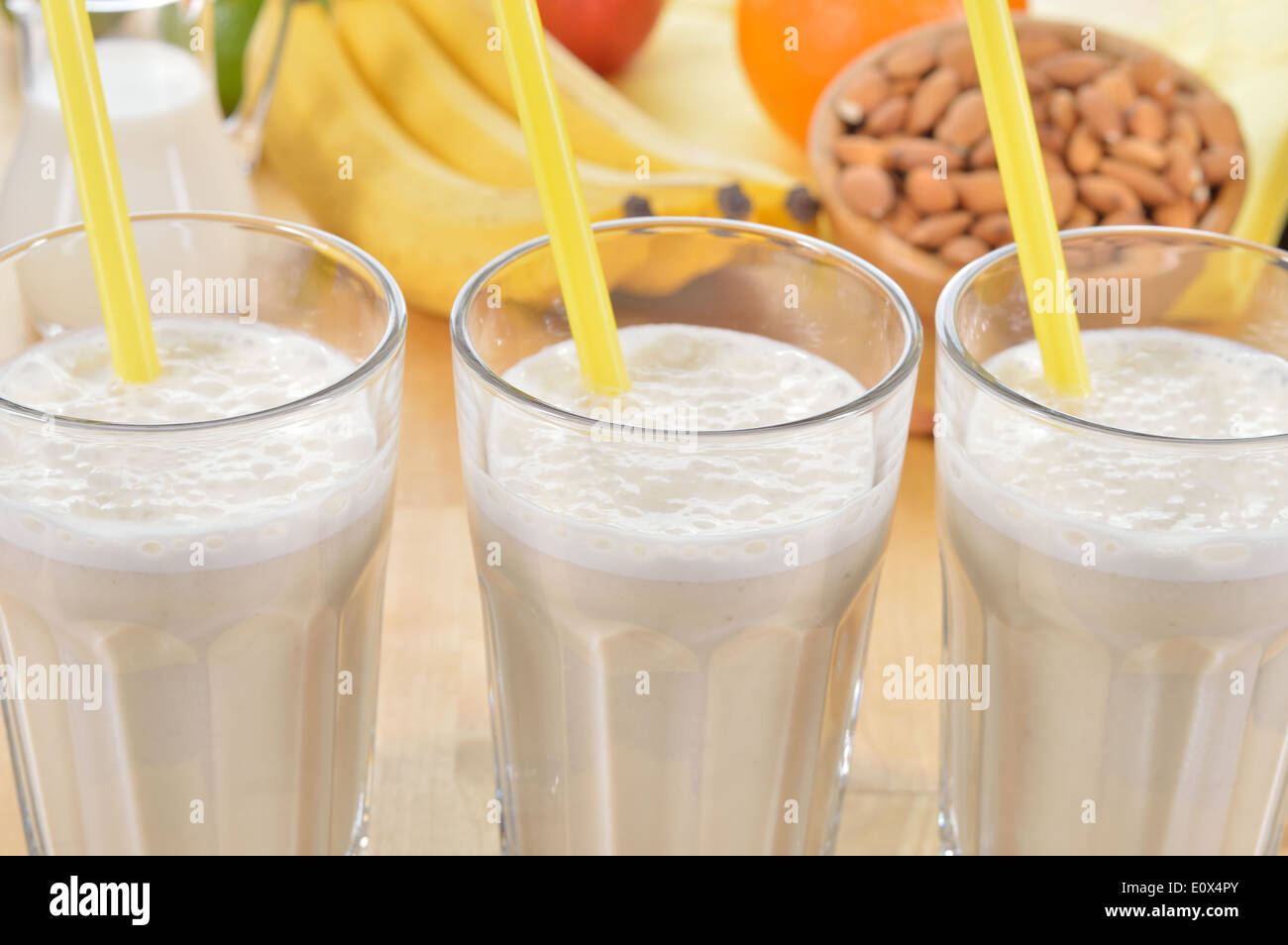 Banana and almond milk smoothie in a glass on a kitchen table. Summer drink made of banana, almond milk and few dactyl. Stock Photo