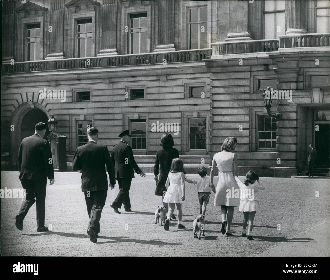 May 05, 1965 - Jackie Kennedy and her sister go to Buckingham Palace with their children: Mrs. Jacquline Kennedy and her two children John, 5, and Caroline, 7, accompanied by her sister, Princess Radziwill, and her two children, walked from the Radziwill home in Buckingham Palace, through the park to Buckingham Palace today. They were invited inside to watch the ceremonial changing of the guard. Photo shows Accompanied by a bodyguard Jackie Kennedy (in black) and her sisiter, Princess Radziwill, walk across the forecourt of Buckingham Palace with their children today. Stock Photo