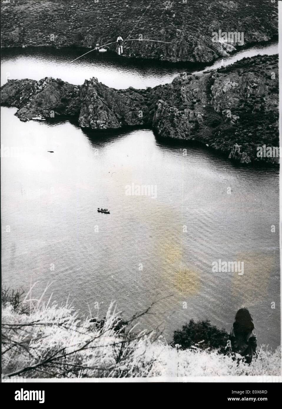 Jul. 07, 1965 - World record tight rope walk; The well known tight rope walker, Henry Rechatin, recently broke the world distance record when he walked one mile on a tight rope over a dam near Saint etienne, France. The feet took him 2 hours 15 minutes. Photo Shows Henry Rechatin seen high above the water as he made his record breaking tight rope crossing. Stock Photo