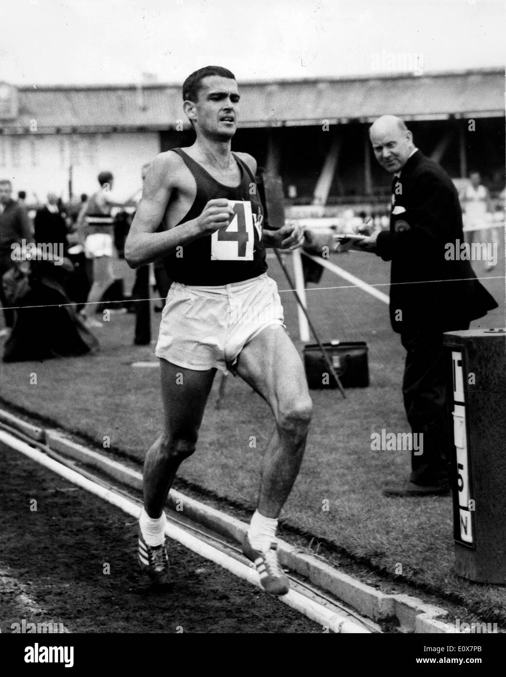 RON CLARKE at the finish line setting a world record running three