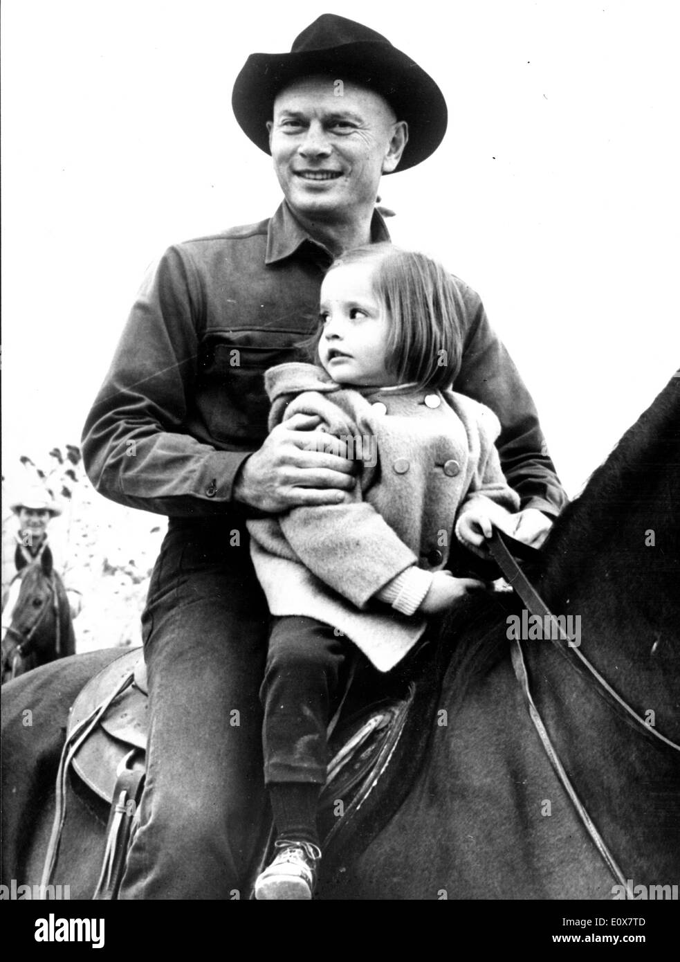 Actor Yul Brynner riding horseback with his daughter Victoria Stock Photo
