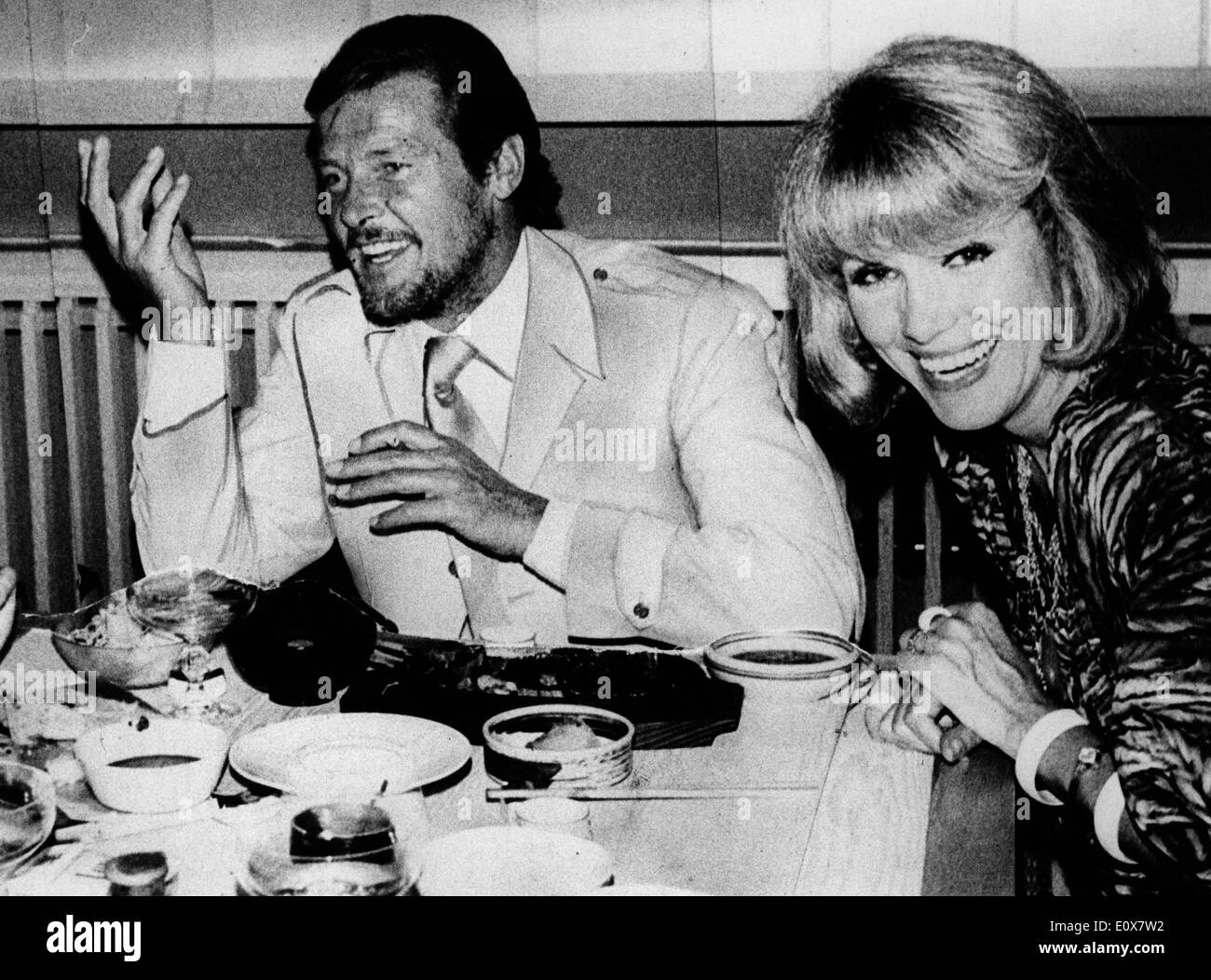 Performing Duo The Kessler Twins out to dinner with Roger Moore Stock Photo