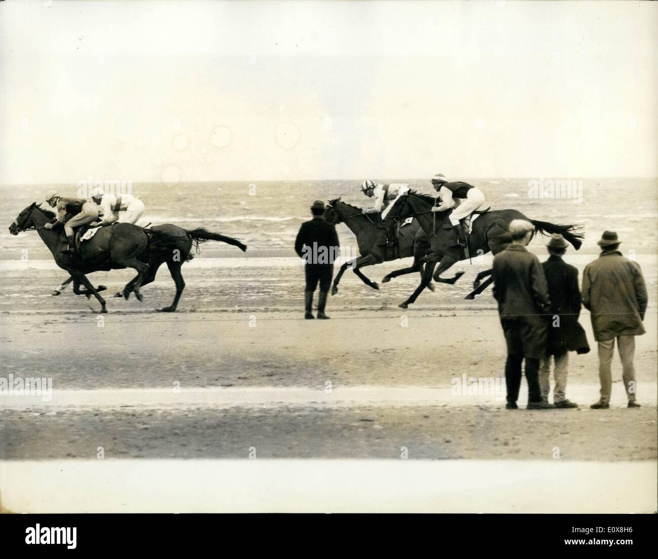 Aug. 08, 1965 - The Tide Is Out - And The Laytown Race Are On: Two hours before the off, the racecourse was 6ft. under the Irish Sea. But the tide soon went down - and the Horse lined up to start the Laytown Races on the beach. The Laytown races, run under arctic racing rules have been held annually for as long as any one can remember. There's nothing quite like it in Ireland or anywhere also in the world. For any ordinary Clark of the Course the Whole thing would be nerve racing Stock Photo