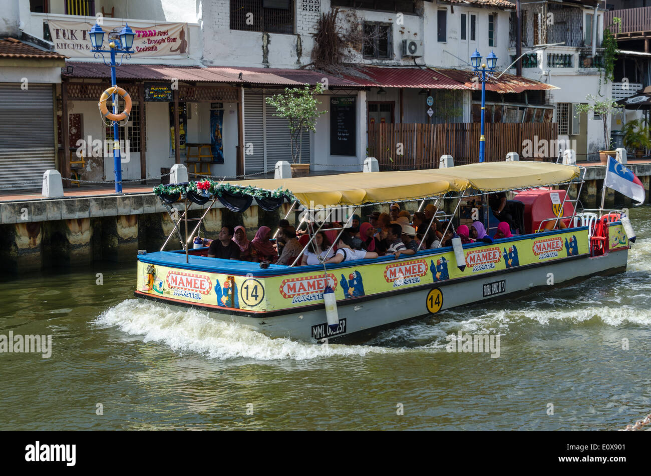 Tourist boat taking sightseers on a river trip in the old Malaysian town of Melaka Stock Photo