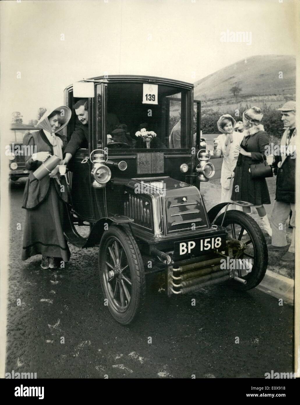 Nov. 11, 1965 - Veteran car run from London to Brighton drives served with hot drinking chocolate en route; 250 Veteran cars were entered for the annual Royal Automobile Club's Veteran Car run from London to Brighton, starting from Hyde Park this morning. Befitting the occasion, girls dressed in period costumes served hot chocolate drinks from a veteran truck on a lay by, near Pyscombe, seven miles from Brighton Stock Photo