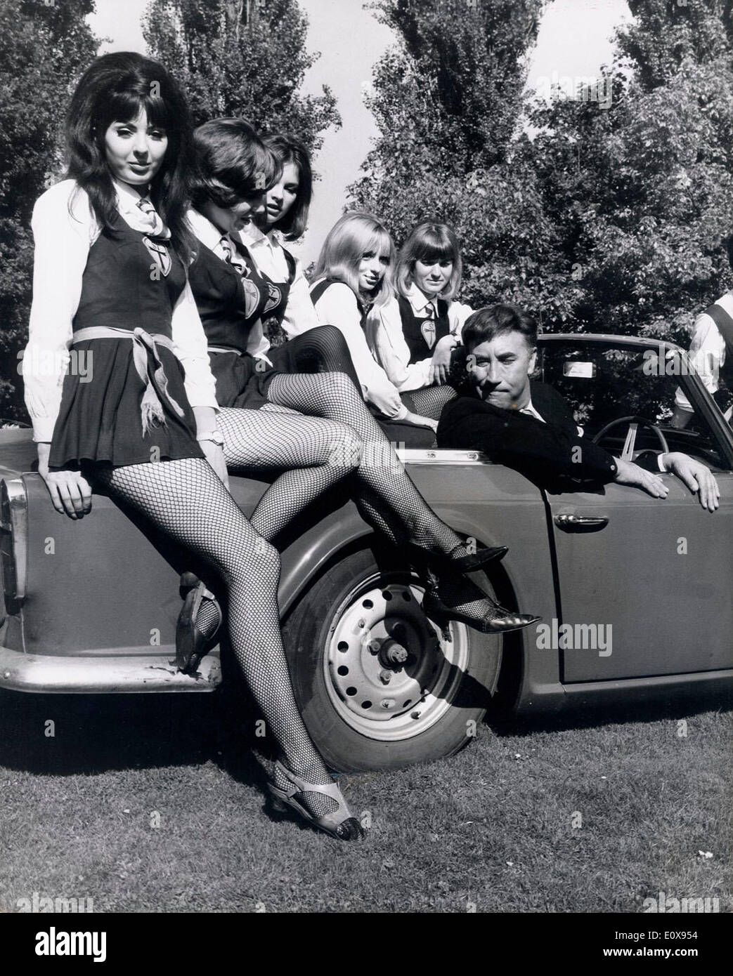 Oct 04, 1965 - Surrey, England, United Kingdom - FRANKIE HOWERD sits in a sports car with some of the girls from St. Trinians School at Shepperton Studios. Howerd is to start as a train robber in the film ''The Great St. Trinian's Train Robbery''. Stock Photo