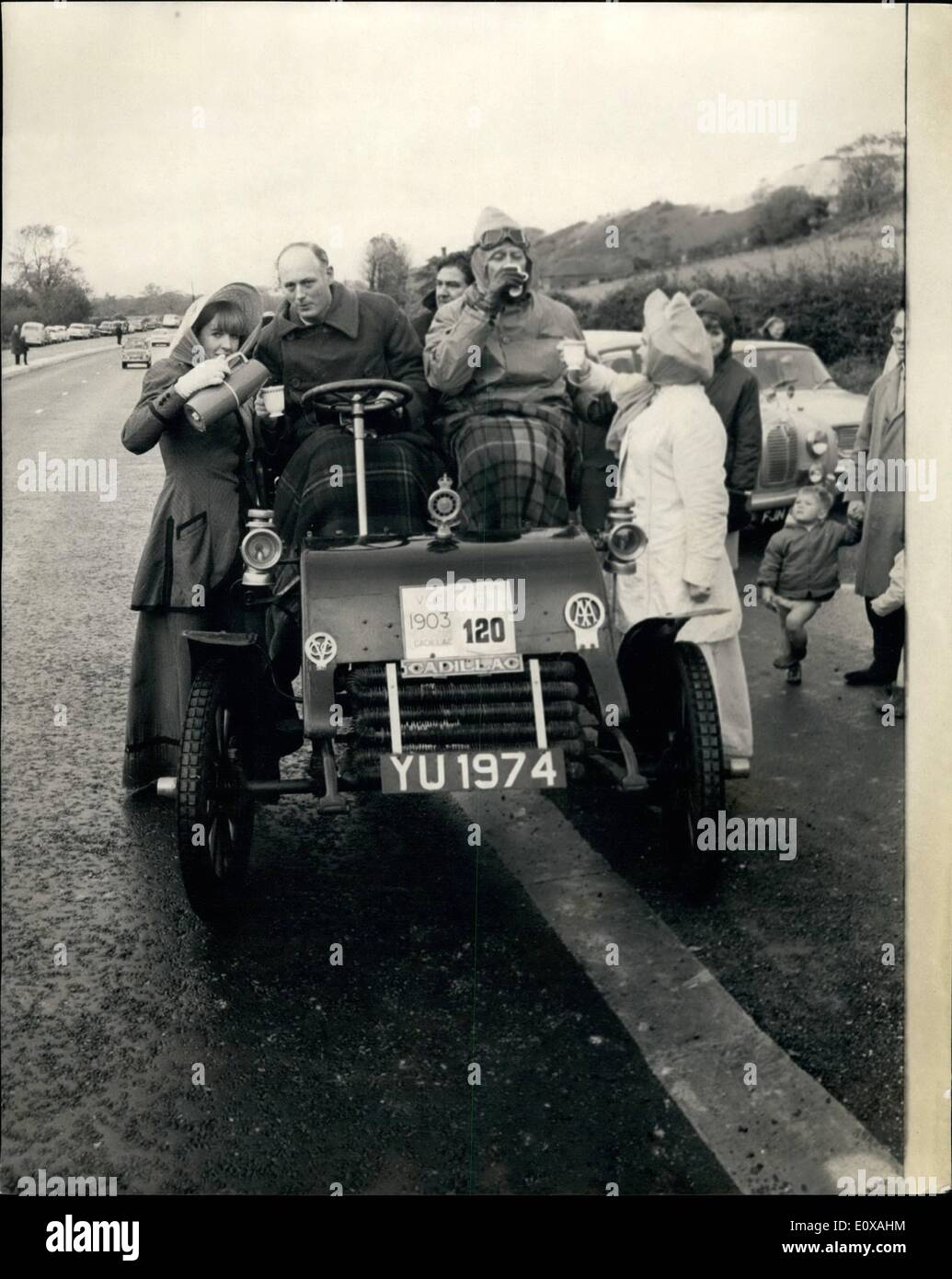 Nov. 11, 1965 - VETERAN CAR RUN FROM LONDON TO BRIGHTON DRIVERE SERVED WITH HOT DRINKING CHOCOLATE EN-ROUTE 250 Veteran cars were entered for the annual Royal Automobile Club, Veteran Car Run from London to Brighton, starting from Ryde Park this morning. Befitting the seccasion, girls dressed in period costumes served hot chocolate drinks from a veteran truck on a lap-by, near Pyscombe, seven miles from Brighton. PHOTO SHOWS LORD MONTAGUE of Beaulleu, driving a 1903 CADILLAC' gets a drink of hot chocolate from SARAH QUENMELL, dressed in period *costume on the lay-by today Stock Photo