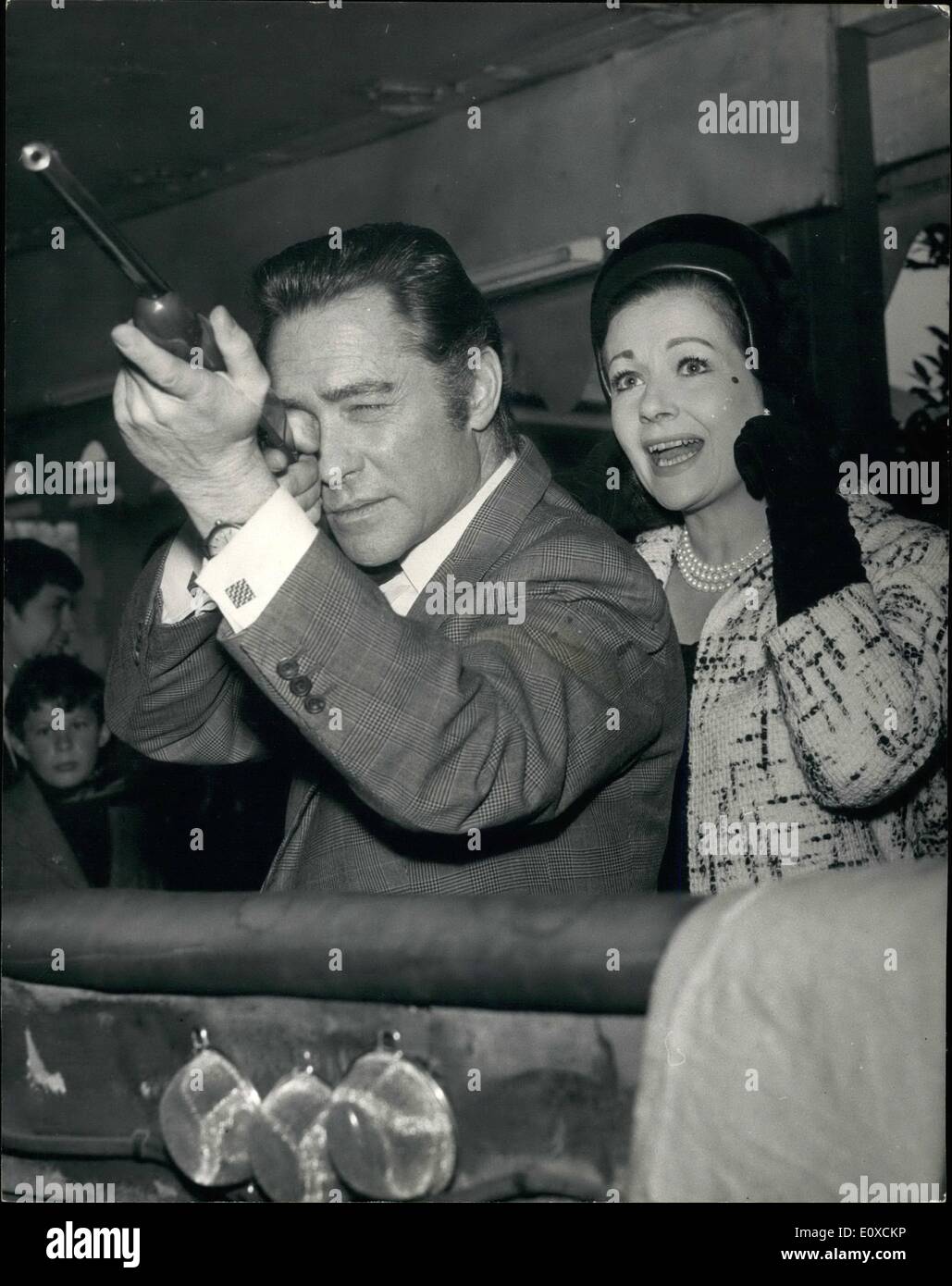 Apr. 04, 1966 - The opening of the Battersea Festival Gardens and Fun Fair: Actress Margaret Lockwood and actor Richard Tood, who play opposite each other in Oscar Wilde's ''An Ideal Husband'' at the Strand Theatre, were the quests of honour this afternoon at the opening of the Battersea Festival and Fun Fair. Photo Shows Margaret Lockwood holds her fingers to her ears as Richard Todd tries out his skill on the rifle range at the Festival this afternoon. Stock Photo
