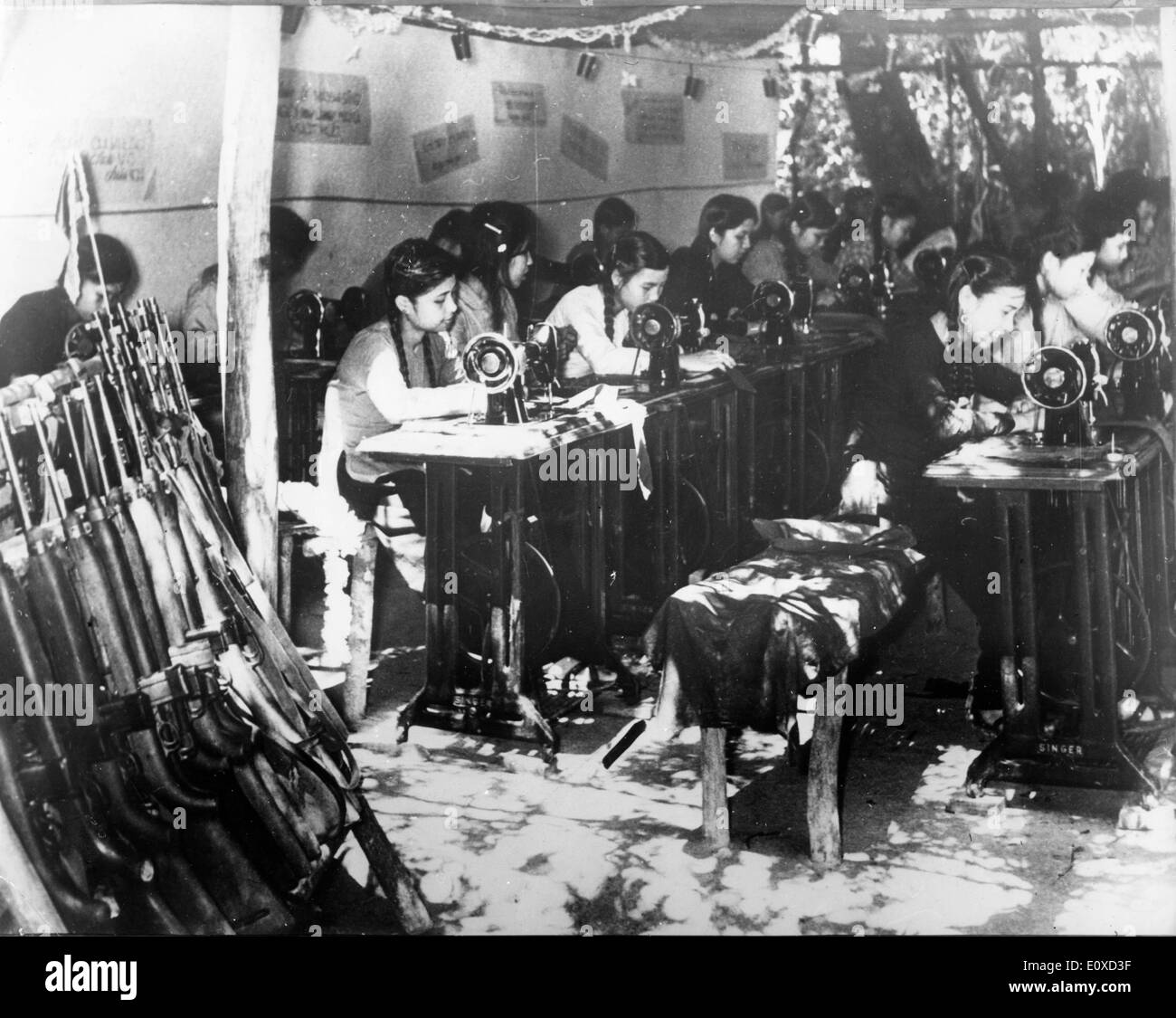 Workers making uniforms during Vietnam War Stock Photo