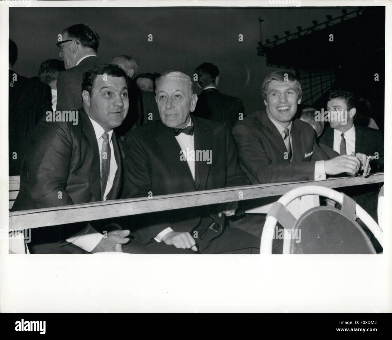 May 05, 1966 - At the Ring Side: Former World Heavyweight Champion Rocky Marciano, left, film actor George Raft, And British Heavyweight Billy Walker, right, Pictured at the ring side before the World Championship title fight between world champion Cassius Clay, and British Challenger Henry Cooper ,at Highbury stadium, London, this evening, May 21. Stock Photo