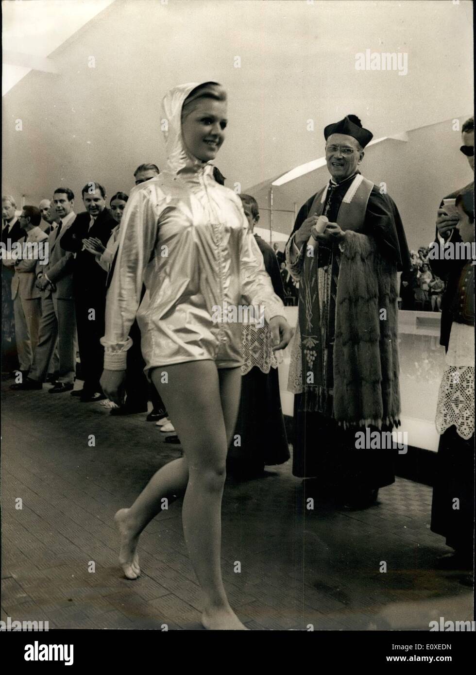 Jul. 07, 1966 - The Priest and the model: A sidelight of the opening of the Deauville Olympic Swimming Pool. The Priest who blessed the new pool has a fatherly smile for the pretty Mannequin modelling beach near specially designed for the occasion. Stock Photo