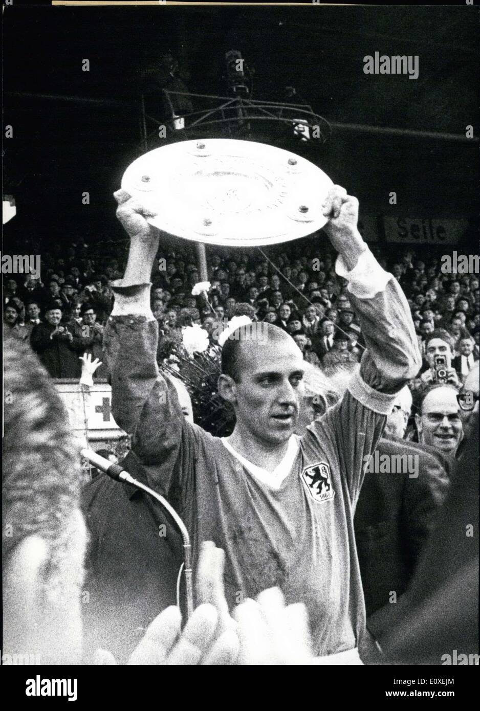 May 28, 1966 - Pictured here is Captain Grosser of 1860 M?nchen as he raises the championship shell. 1860 M?nchen won the Bundesliga, Germany's soccer association, for the first time, playing against Hamburger Sportverein in Munich on 5-28-1966. In the background is Chancellor Erhard and Munich mayor Dr. Vogel. Stock Photo