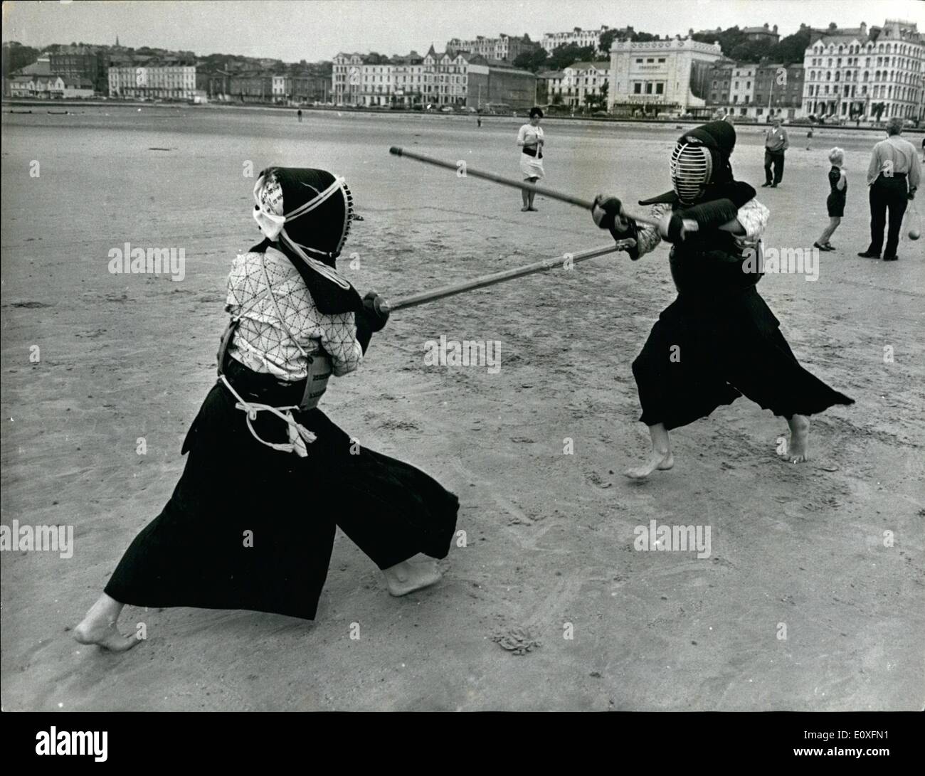 Sep. 09, 1966 - No- These Aren't Japanese Warriors on the Beach: Some families prefer just to laze in the sun, others like to fill in their time on the beaches by building sand-castle, or try their football skill with a plastic ball. But all these typically-British seaside activities are much too tame for the Maddame family. their idea of holiday fun is to while away the hours with a few brisk sessions of kendo - a 2,000 year old Japanese battle sport featuring some neat sword-play a few blood curdling cries, and a number of sickening thuds Stock Photo