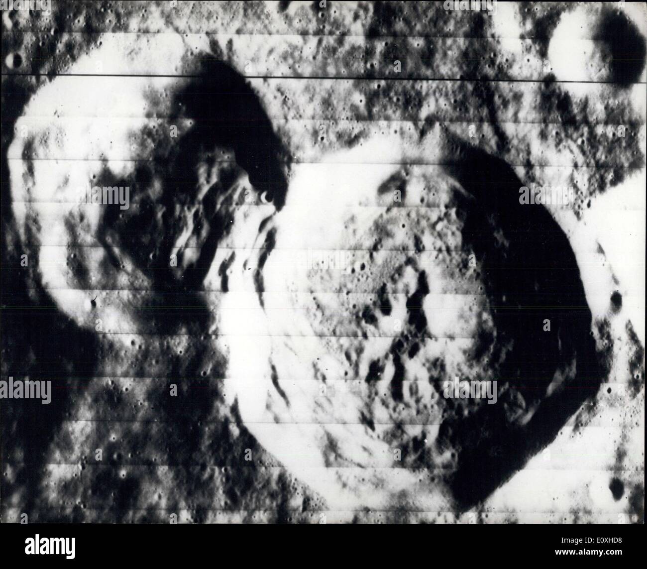 Oct. 14, 1966 - Hidden Side Of The Moon: A high resolution photograph made by the National Arenautics and space Administration's Lunar Orbiter ~ spacecraft on August 26th, 1966, of an area on the hidden side of the Moon shows an unusual geological phenomenon formed by the super position of a large erater on an older, slightly smaller one. Displacement of wall material in the older ~rater is clearly visible. North is at the top of the picture when it is viewed with the larger of the two craters at the upper left and the smaller erater to its lower right Stock Photo