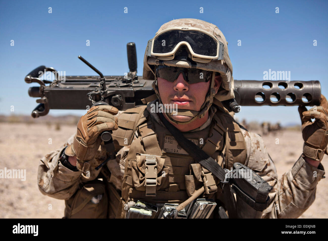 A US Marine machine gunner carries the barrel of a Browning M2 .50 caliber machine gun during the Assault Support Tactics training on Yuma Proving Grounds April 14, 2014 in Yuma, Arizona. Stock Photo