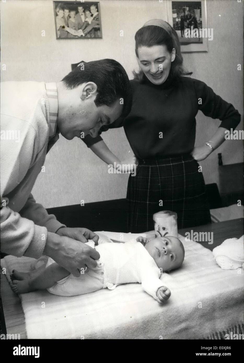 Feb. 02, 1967 - Little Thomas is not ambitious to walk in his famous fathers footsteps as it seems. When the six weeks old son of the former Olympic and World Champion Manfred Schnelldorfer was shown the skating ice for the first time he closed his eyes and slept on peacefully in his father's arms. The ex ice skating star and architect wasn't so eager himself to bring his little son into the ring but he was urged by his pupils. Photo shows Manfred Schnelldorfer dressing his son Thomas. Stock Photo