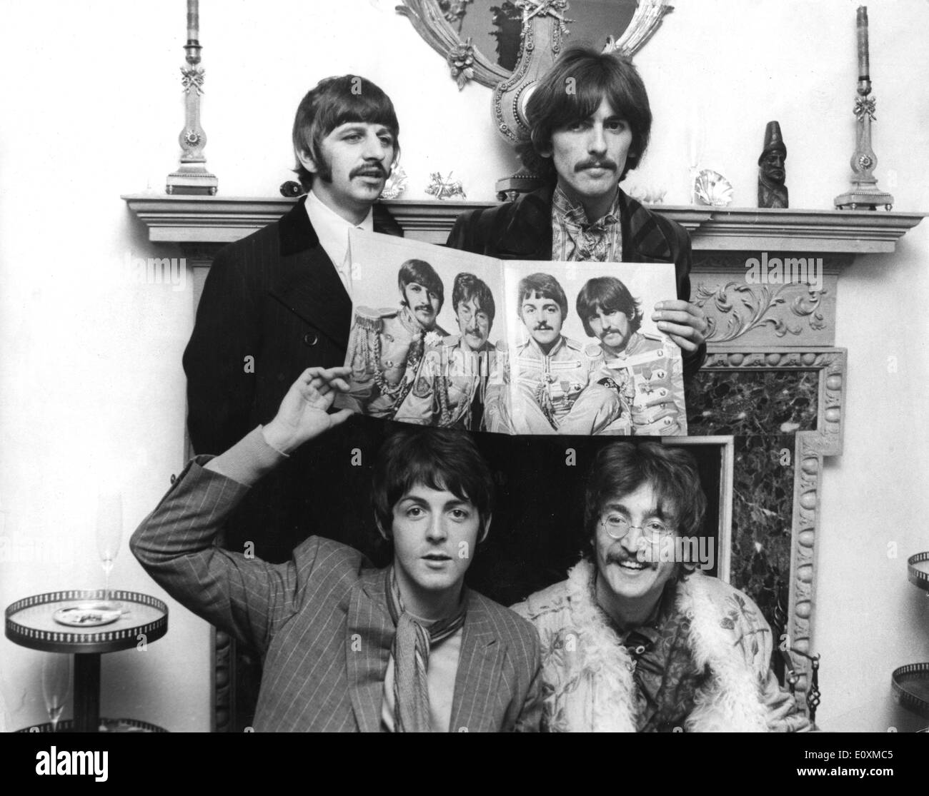 The Beatles holding up a poster of themselves Stock Photo