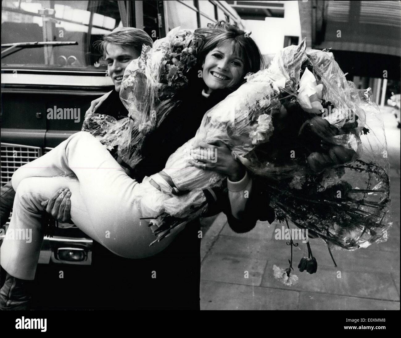 Apr. 04, 1967 - Sandie Shaw returns from triumph in the Eurovision song contest.: Sandie Shaw arrived at London Airport yesterday after her triumph in the Eurovision Song Contest, at which she sang British's entry ''Puppet on a String''. Britain won by the widest margin every with 47 votes to Ireland's 22 and France's 20. The contest was held in Vienna. Photo shows Sandie Shaw is swept off her fact by singer Adam Faith, who returned with her from Vienna yesterday at London airport. Stock Photo