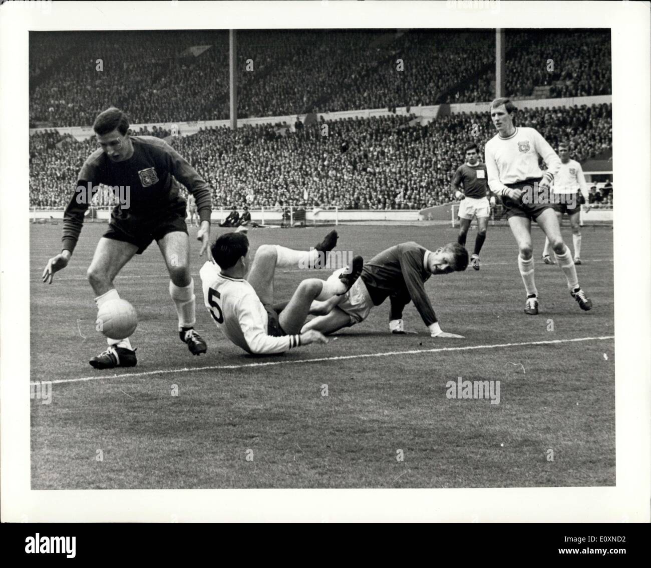 Apr. 22, 1967 - Amateur Cup Final: Enfield goalkeeper Ian Wolstenholem gathers the ball from temmates Alf D'arcy (left, Captain) and Howard Moxton (right) and Skelmersdale United player Wally Bennett (center) during an attack on the enfiled goal in their Amateur cup final at Wembley stadium, London, today, April 22. Enfield drew 0-0 with Skelmersdale after extra time. Stock Photo