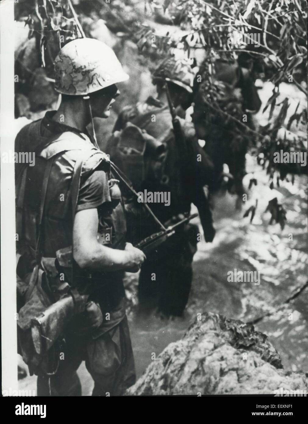 May 04, 1967 - War in Vietnam Wet Patrol: American Marines wade through a Jungle stream in search of Vist cong using the same waterway to mask their movements. The flowing water muffles movement as the infantrymen go forward on their mission. Stock Photo