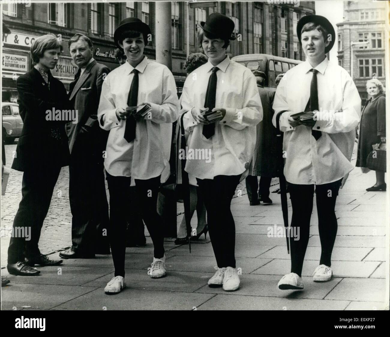 Jul. 07, 1967 - Girls Step out in Shirts; Three girls stepped out in shirts yesterday. They stopped the traffic and had head turning. tights, mob-bloomers, bowler hats and rolled umbrellas completed the gentlewoman-about town touch. They were walking round Carlisle's City center to advertise a one day shirt cleaning service Stock Photo
