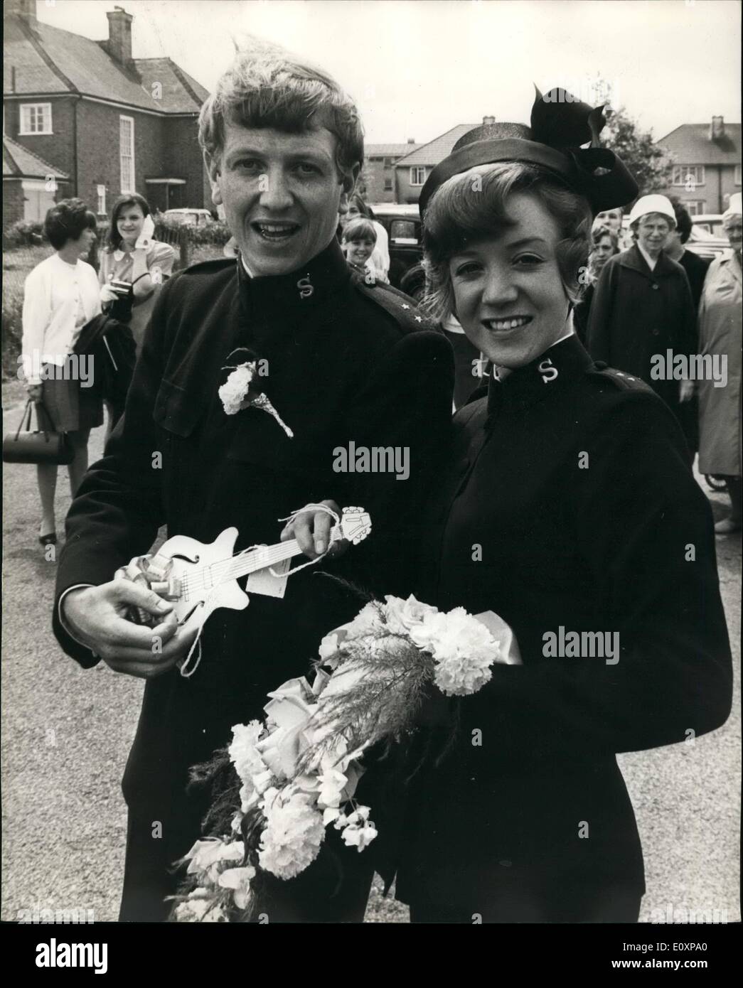 Jul. 07, 1967 - Salvation Army Singer Of the Joystring Weds: Singer Silvia Gair, of the Salvation Army pop group The Joystrring, was married this afternoon to the Group's guitarist, 24 year-old Peter Dalziel at the Parish Church, New Addington, Survey. Photo shows The bride and groom soon at the service. today between them they are holding a mini guitarist. Stock Photo