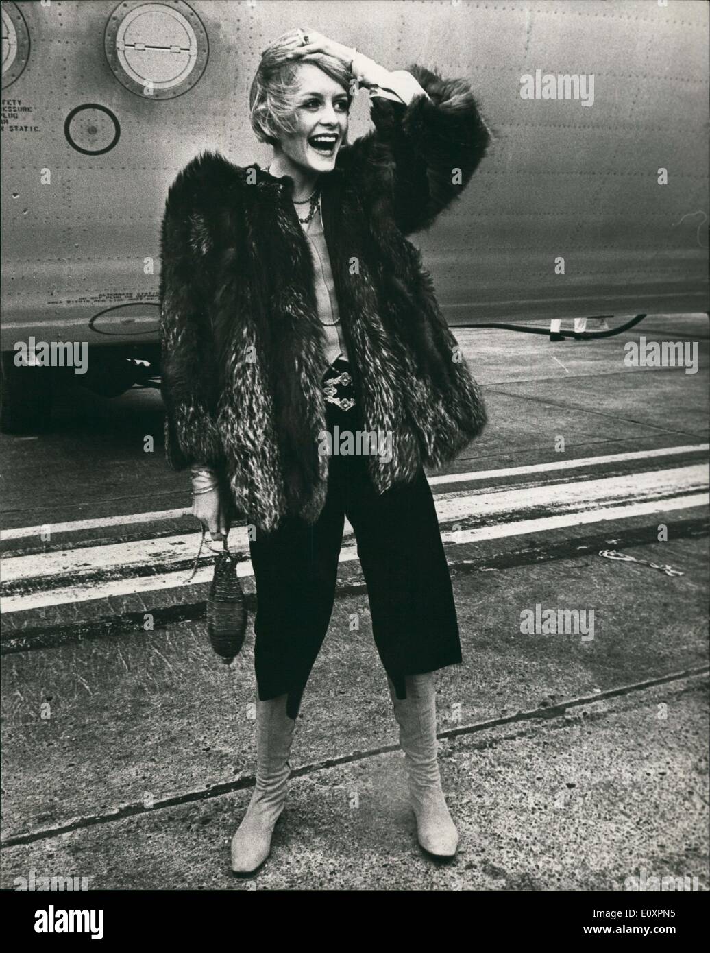 Oct. 10, 1967 - Twiggy off to japan by air to show her fashions: Accompanied by her hoy friend manager, Justin De Villeneuve, Britain's famous model, Twiggy left London Airport today to fly to Japan where she is to show a collection of her fashions. Photo shows pictured on the tarmac at London airport today Twiggy is all dressed up in her huge fur jacket and loose baggy trousers worn with leather boots. Stock Photo