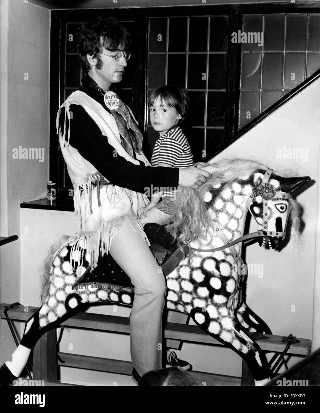 John Lennon and his son Julian riding a rocking horse Stock Photo