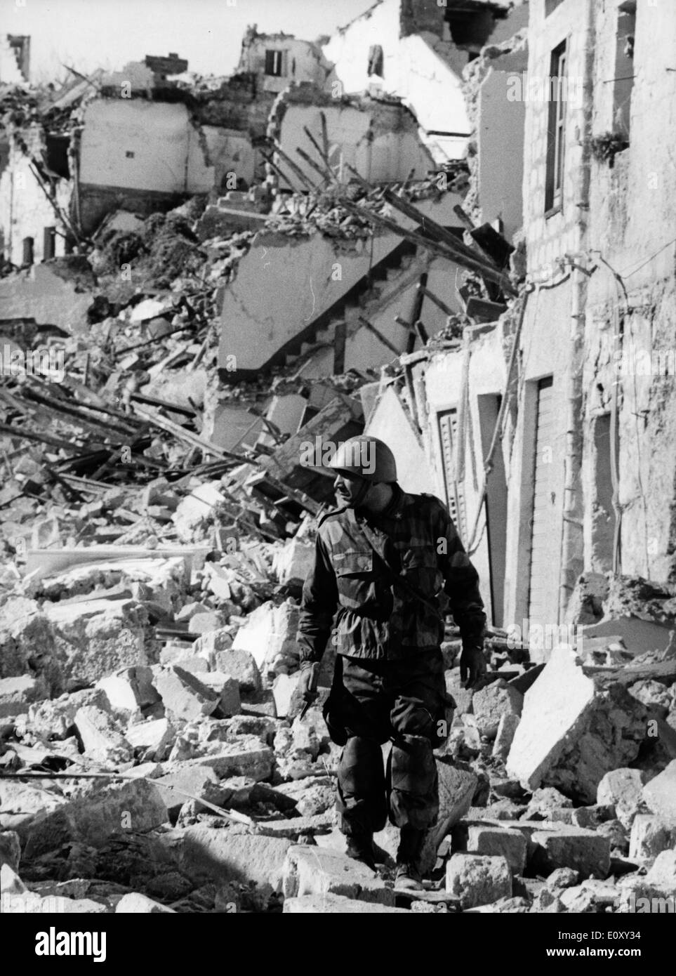 FILE PHOTO - Jan 17, 1968 - Sicily, Italy - A soldier walks through the rubble of the destroyed town of Gibellina where 1,500 of the population of 7,000 lost their lives in the magnitude 7.5 earthquake. Stock Photo